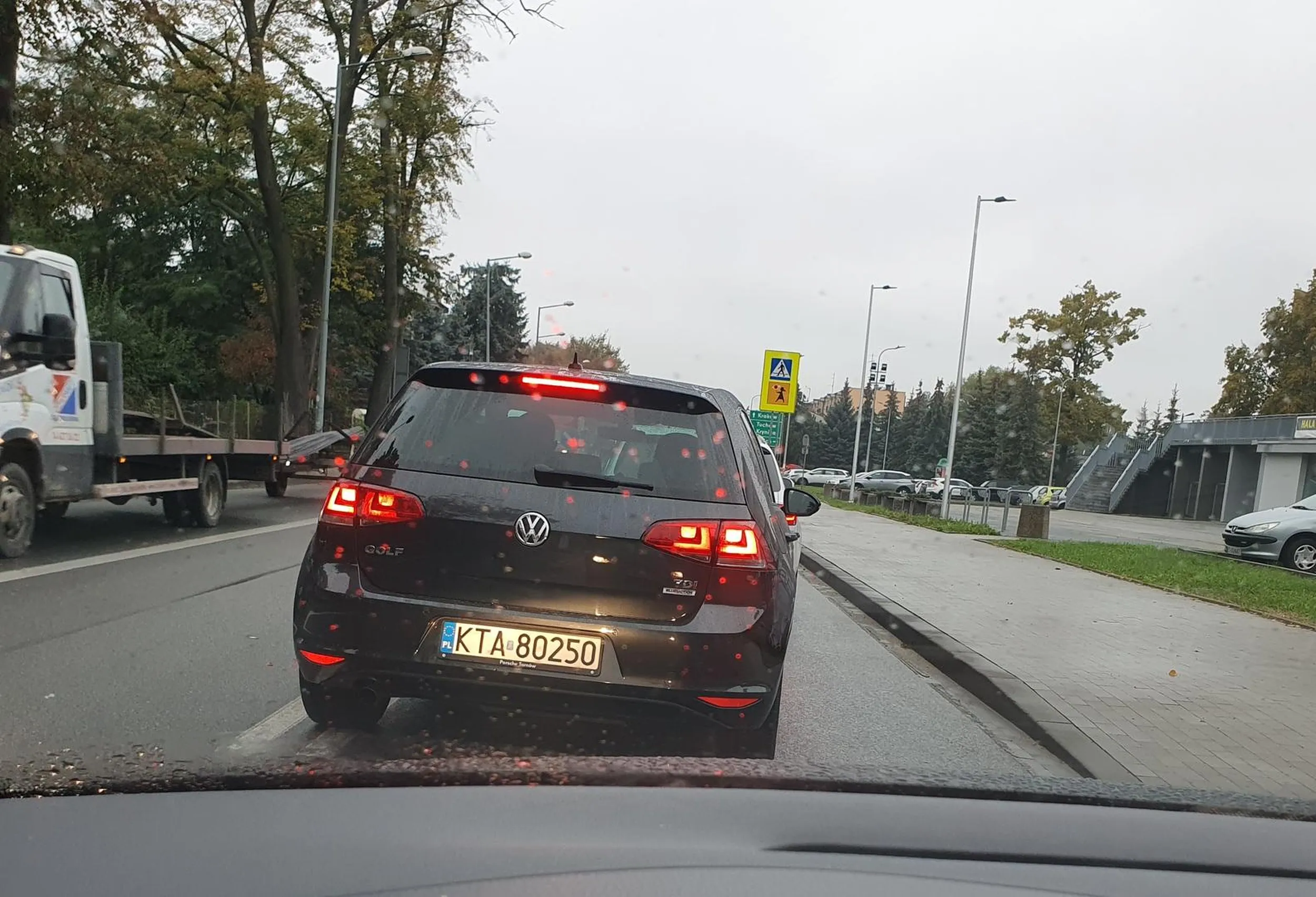 Kierowca omija korek i wpycha się w lukę zostawioną dla skręcających na parking aut z naprzeciwka.