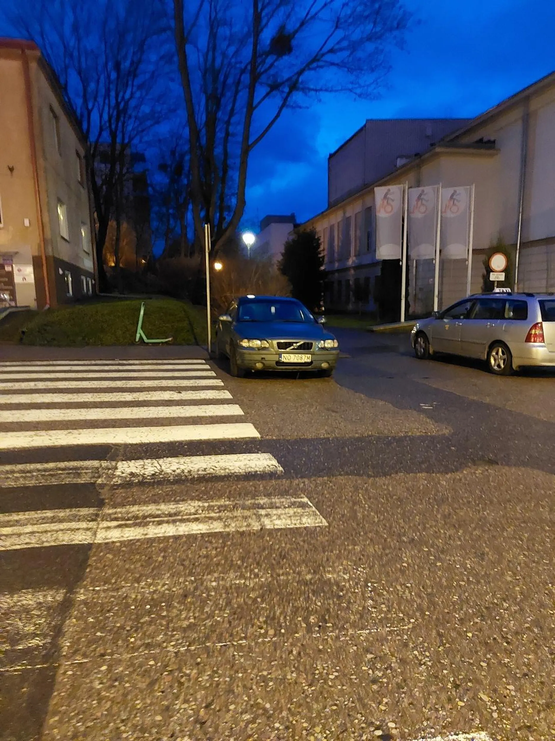 Parkuje przed przejsciem dla pieszych  ograniczając widoczność kierowcom zbliżającym się do przejścia jak i pieszym wchodzącym na przejście. "Trzymaczu kierownicy", bo kierowca to wie gdzie może zaparkować pojazd. Proponuję zapoznać się z art. 49 p. r. d. oraz z taryfikatorem mandatów za wykroczenia drogowe.