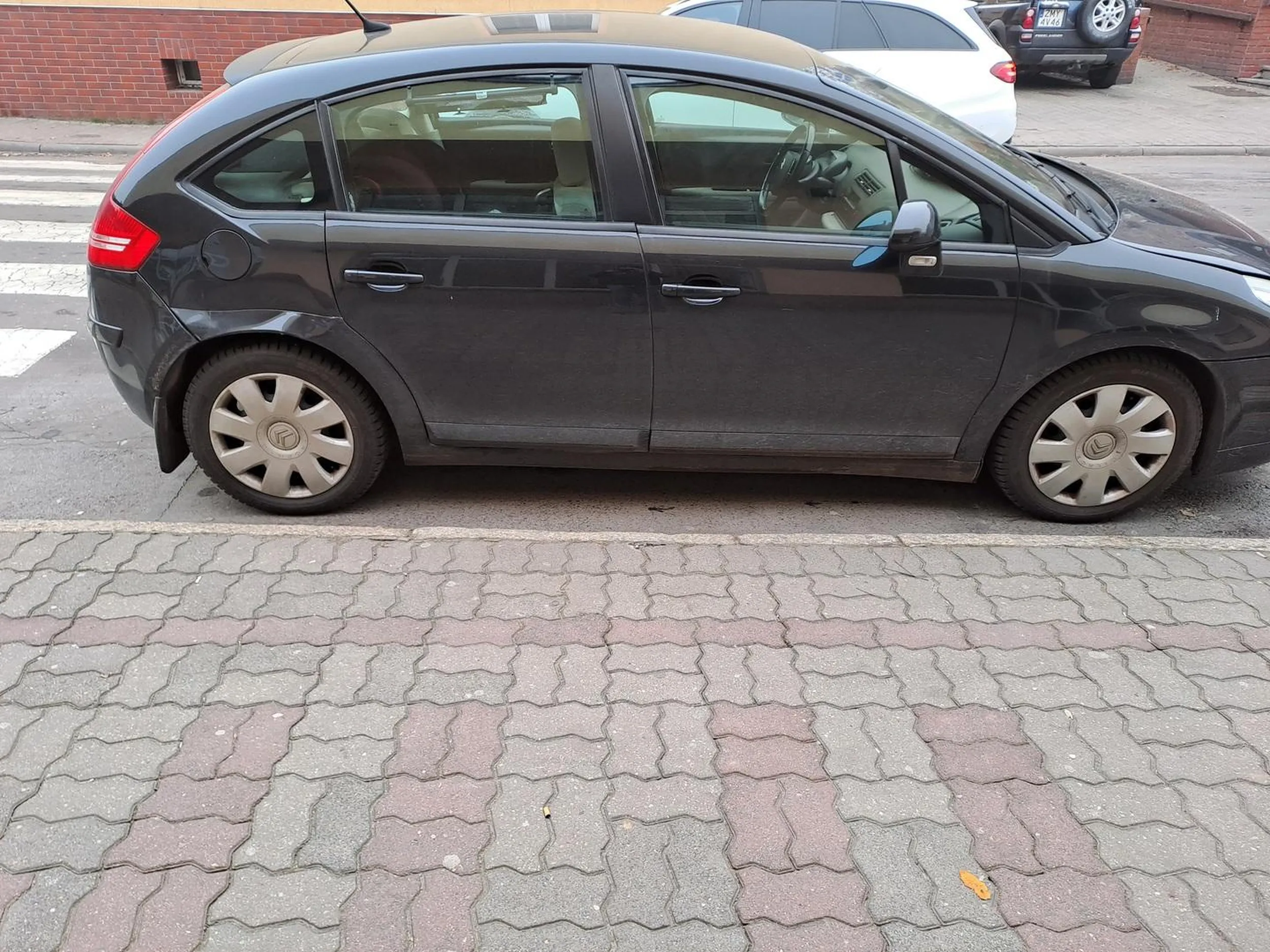 Parkuje zasłaniając przejście dla pieszych jednocześnie zmuszając innych kierowóców do przekraczania osi jezdni oznakowanej podwójną linią ciągłą.