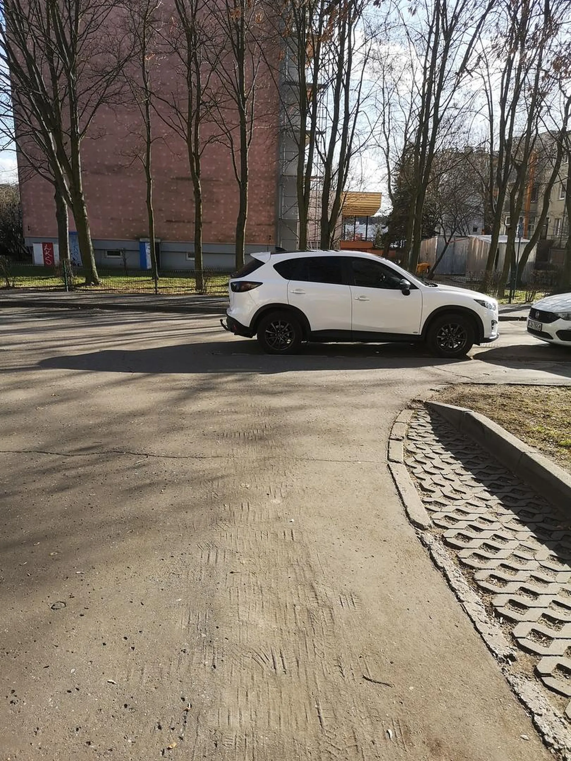 Kobieta zaparkowała tak, że zablokowała ruch na uliczce osiedlowej.