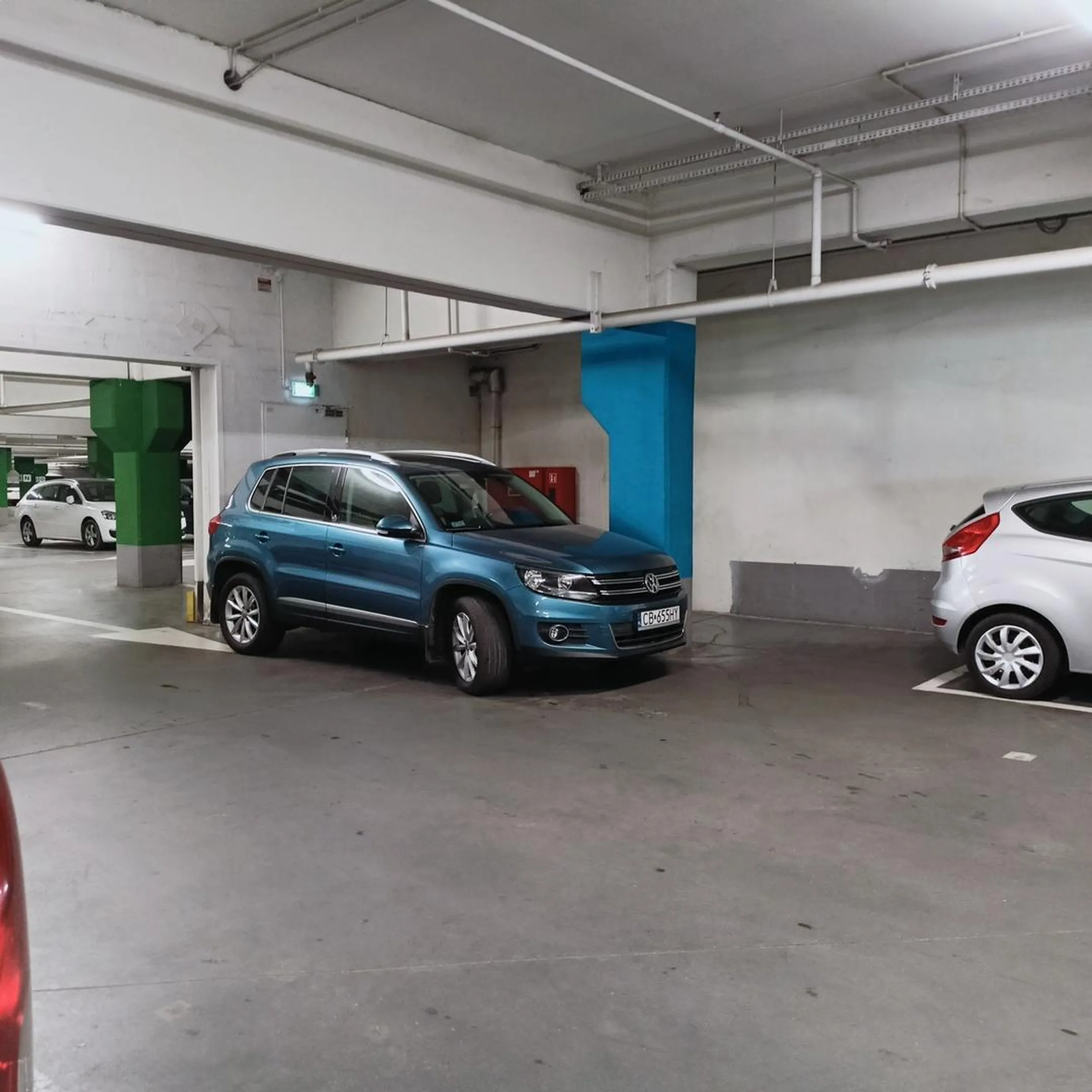 Samochód zaparkowany na drodze w garażu podziemnym w galerii handlowej. Byleby było blisko do wejścia do sklepu