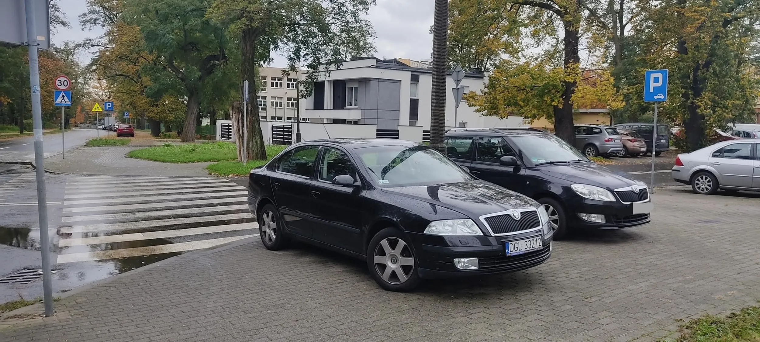 Witam. Kierowca skoda octavia stoi na pasach obok ulicy i zasłania widok przechodnią i nie widać przejeżdżających samochodów