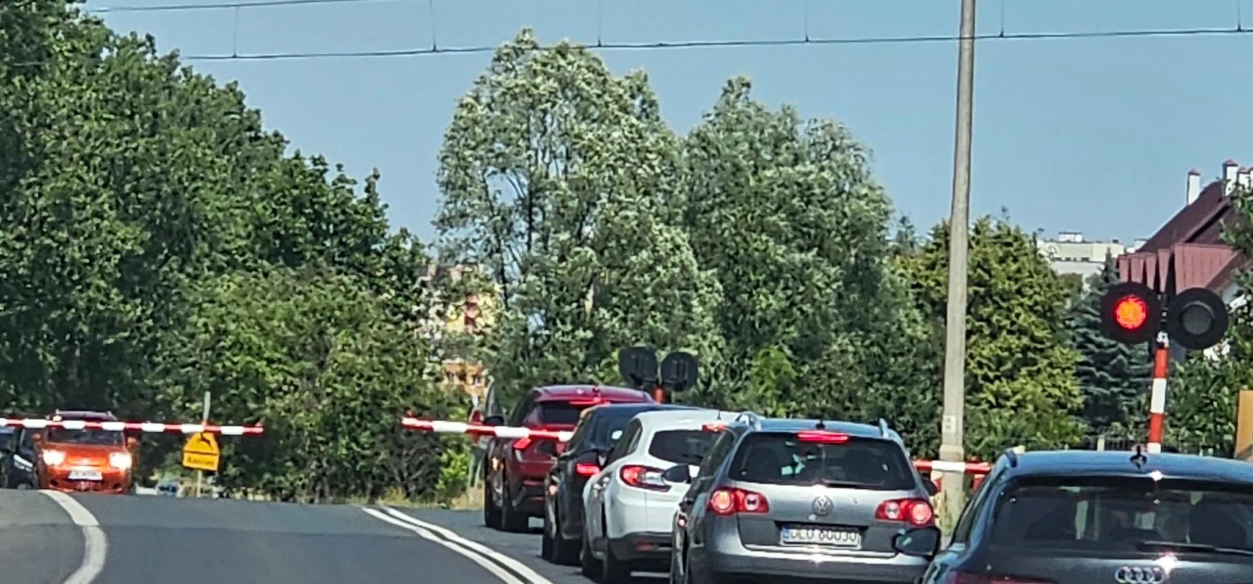 Kierowca zatrzymał się za szlabanem przed torami  kolejowym.