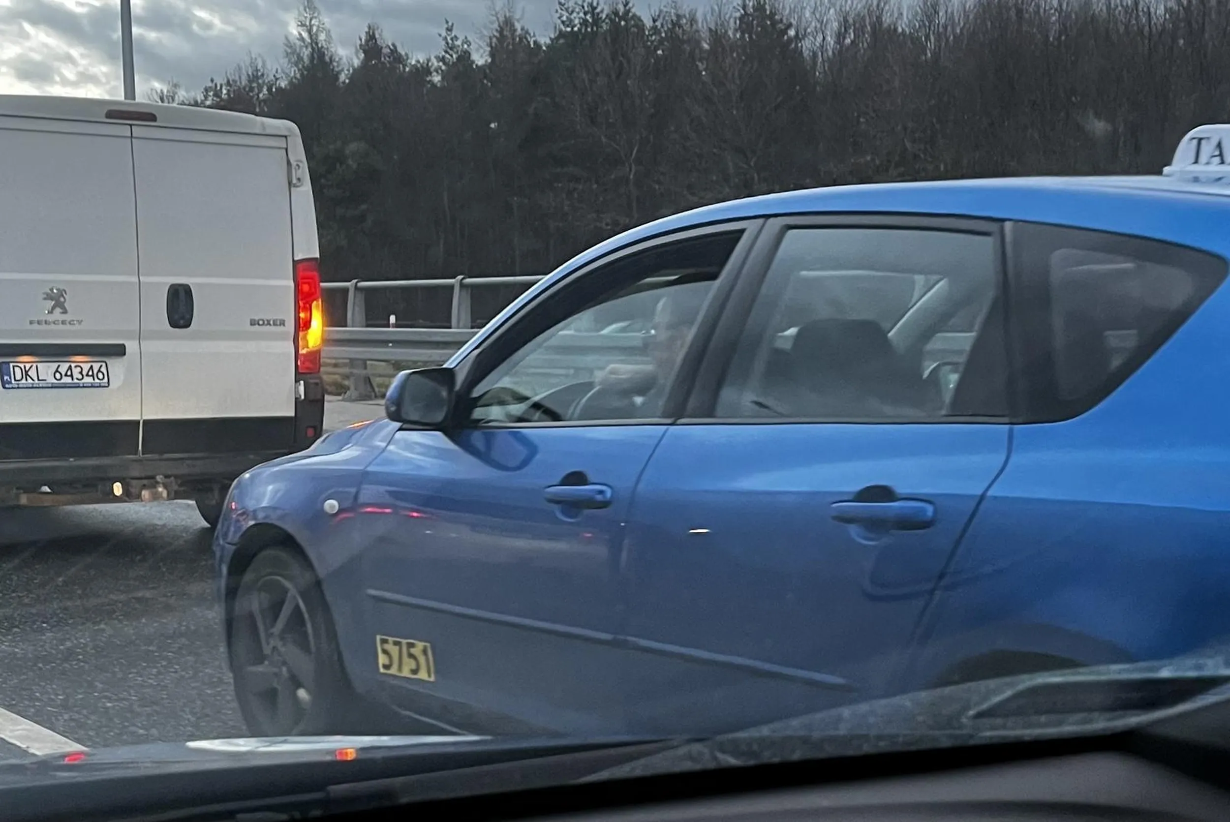 Szalony taksiarz, numer boczny 5751. Wytrąbił przez 10s panią, która nie ruszyła spod świateł w momencie zmiany na zielone, wpychał się w korku w szpary między autami podczas przemieszczania się korka o kilka metrów do przodu, zmieniał pasy bez kierunku, wyzywał innych kierowców. Jechał w kierunku lotniska sam, czyli nie można uzasadnić próbą dowiezienia spóźnionego klienta. Przykry egzemplarz drogowego agresora.