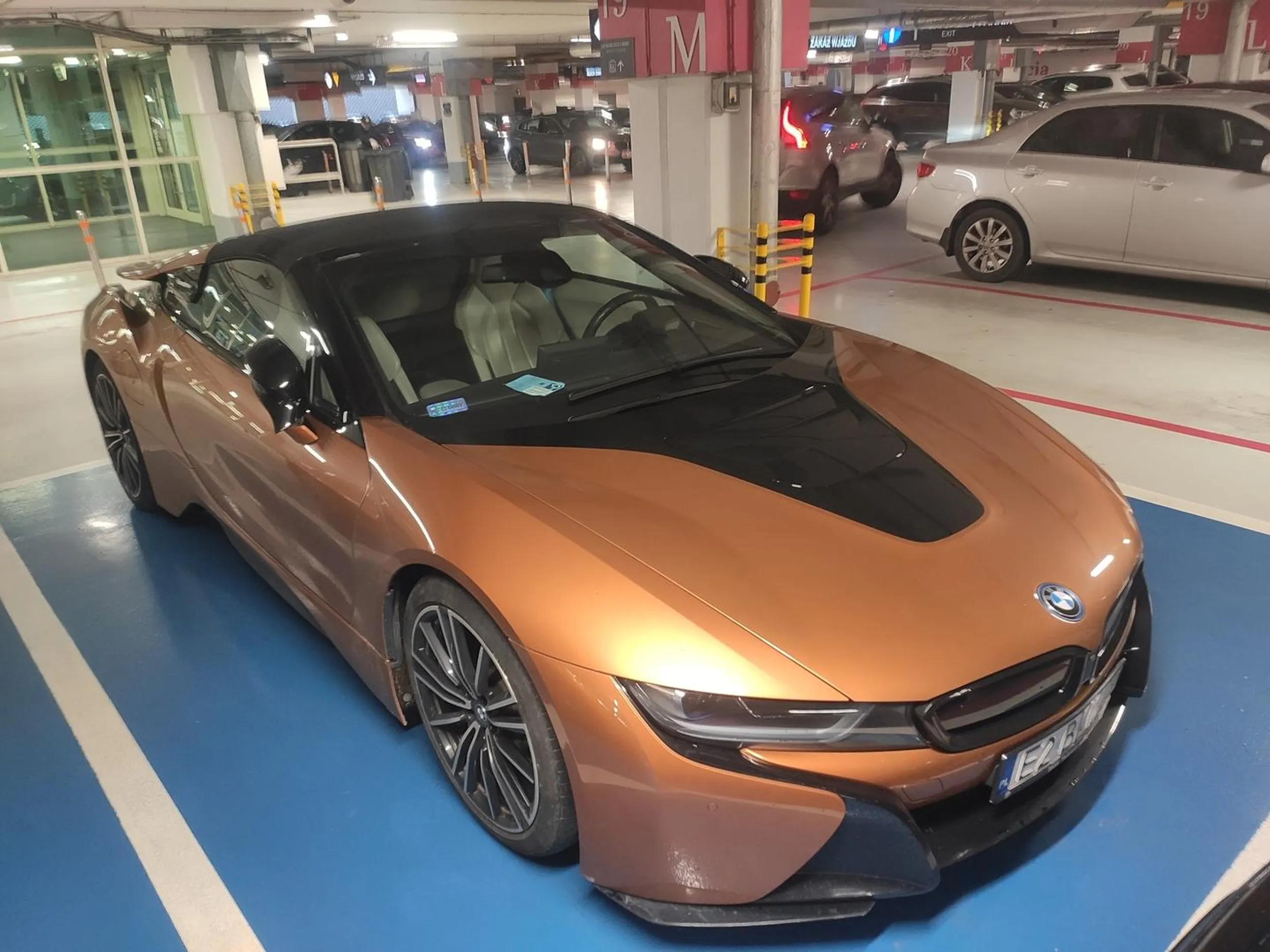 BMW I8 oczywiście stoi na niebieskim miejscu pod drzwiami galerii. Karta niepełnosprawnego za szybą... wygląda jak podróbka z netu