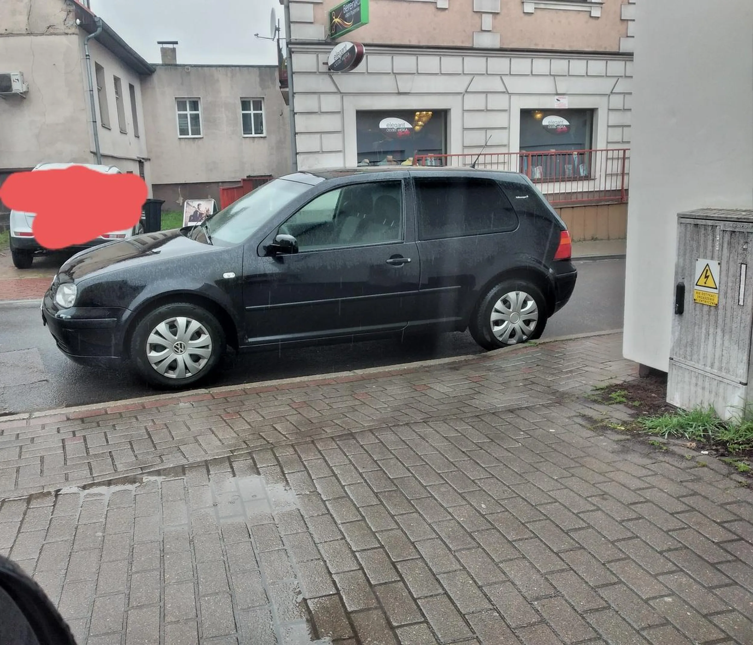 Kierowca parkuje przy wyjeździe. Wyjeżdżać trzeba przez wysoki krawężnik.