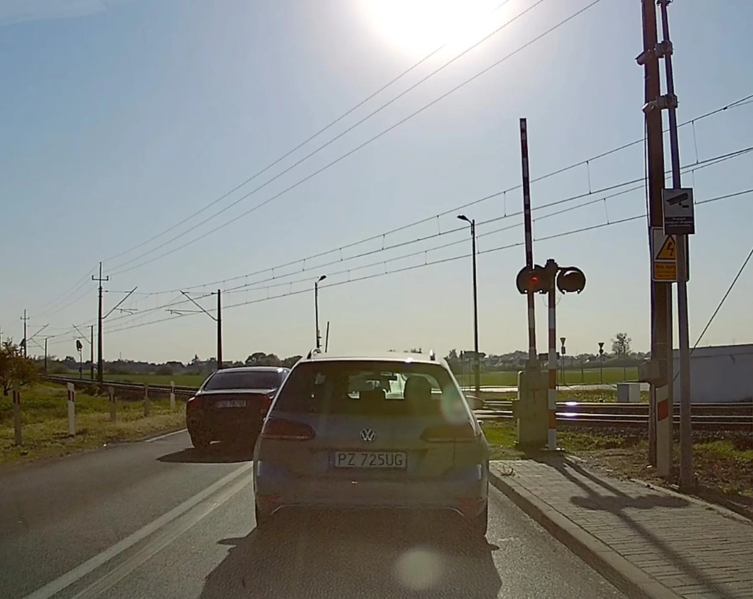 Przekroczenie linii podwójnej ciągłej, wyprzedzanie przed przejazdem i wjazd przy wciąż nadawanym sygnale czerwonym. Mam nadzieję, że obsługa monitoringu również zgłosi.