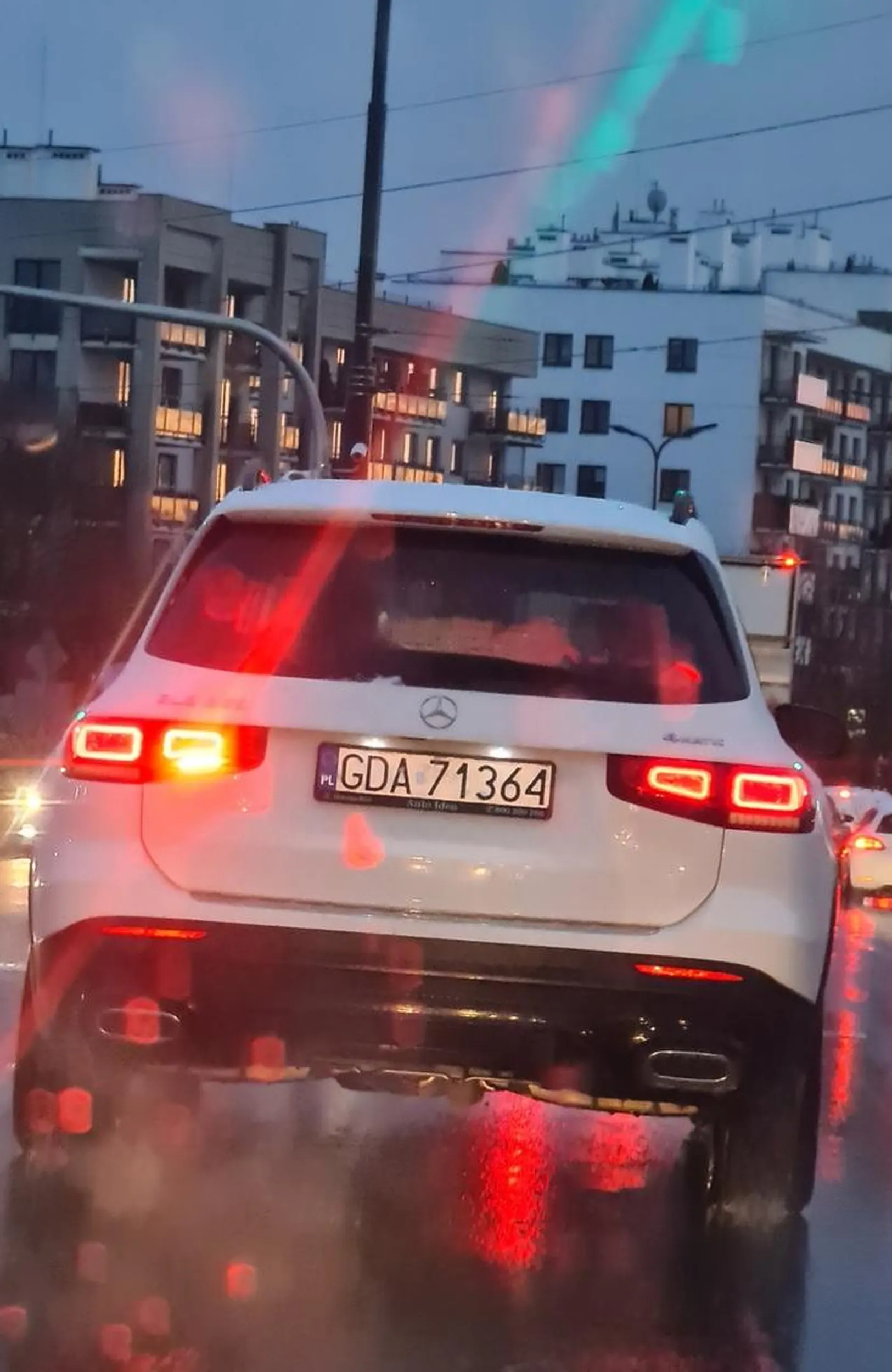 Kierowca tego białego Mercedesa używa w sposób nieprawidłowy (przy dobrej przejrzystości powietrza, tzn. powyżej 50 m) tylnego światła przeciwmgłowego.