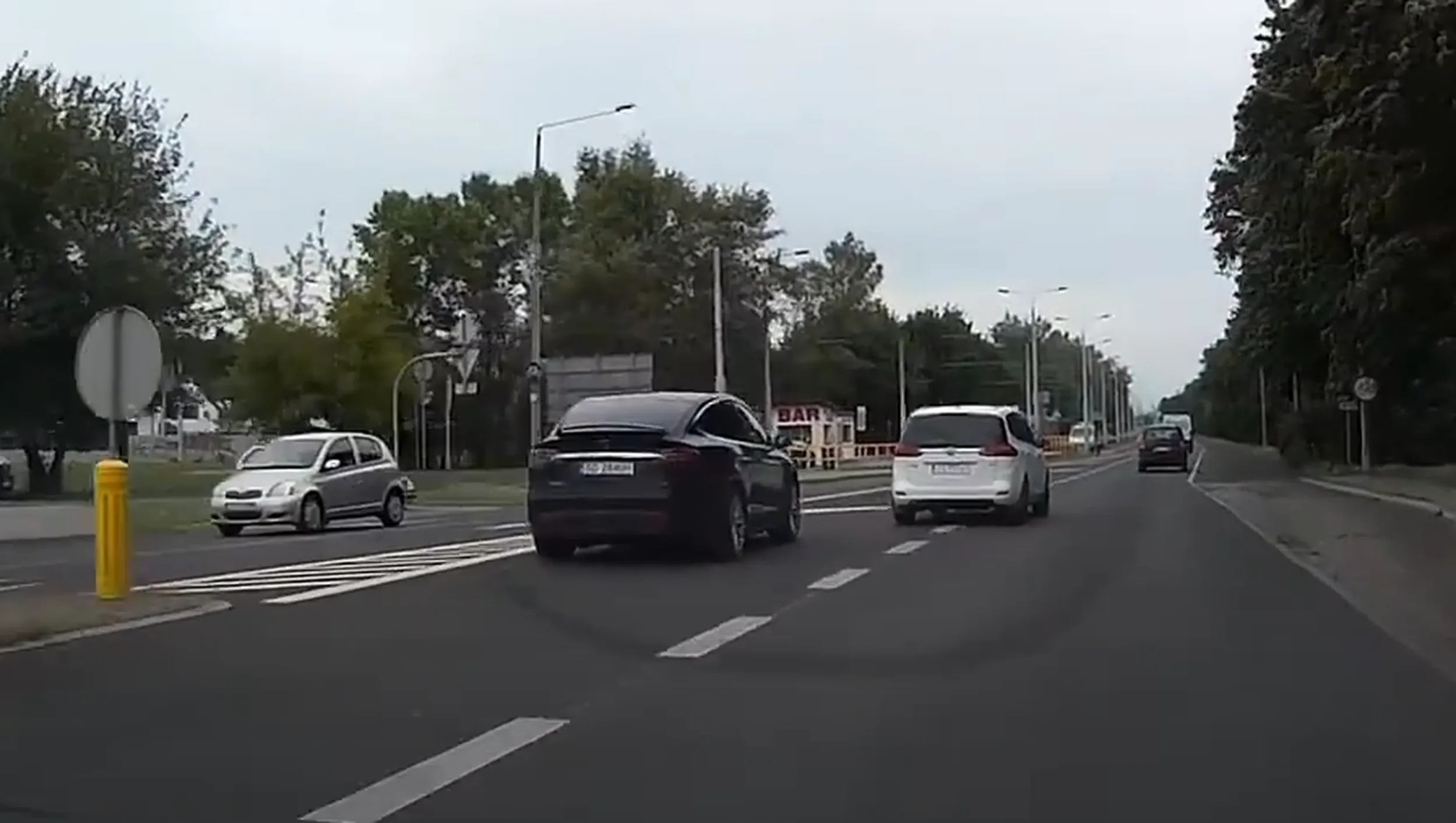 Cwaniak w Tesli, wyprzedza na przejściu dla pieszych i wpycha sie na chama przed wyprzedzone auto.