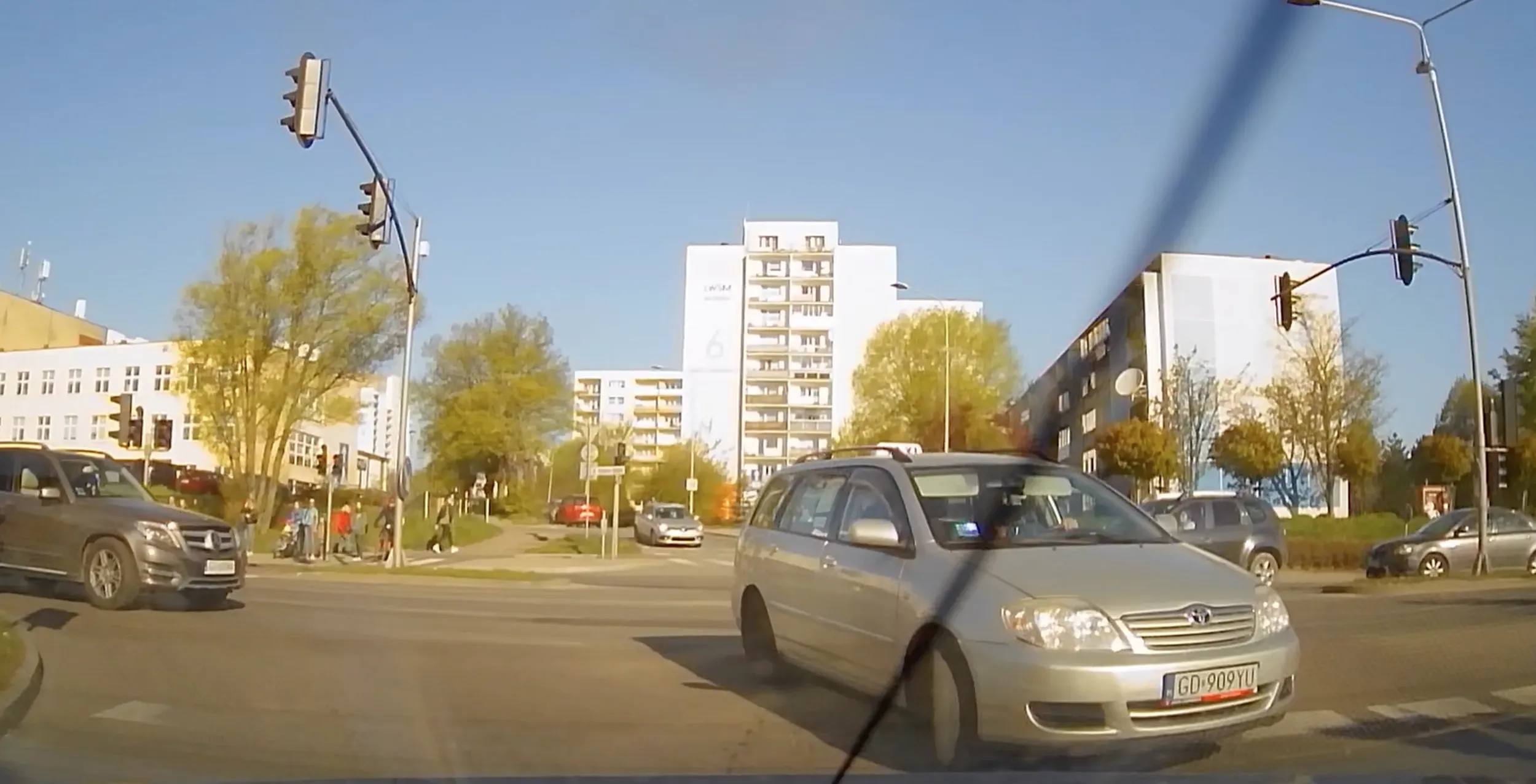 Z lewego służącego do jazdy na wprost Sasza wali w prawo pod prąd i prosto pod autobus. W samochodzie pasażerka, zapewne z aplikacji typu bolt/uber. Filmik zostawiam sobie na pamiątkę. Do taczki a nie za fajerę...