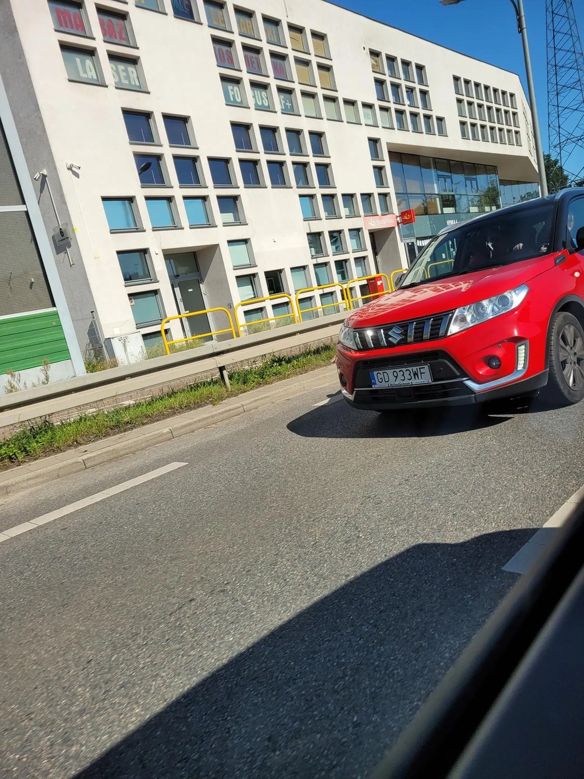 Kobieta siedzącą na miejscu pasażera wyrzuciła śmieci z samochodu na trawnik.