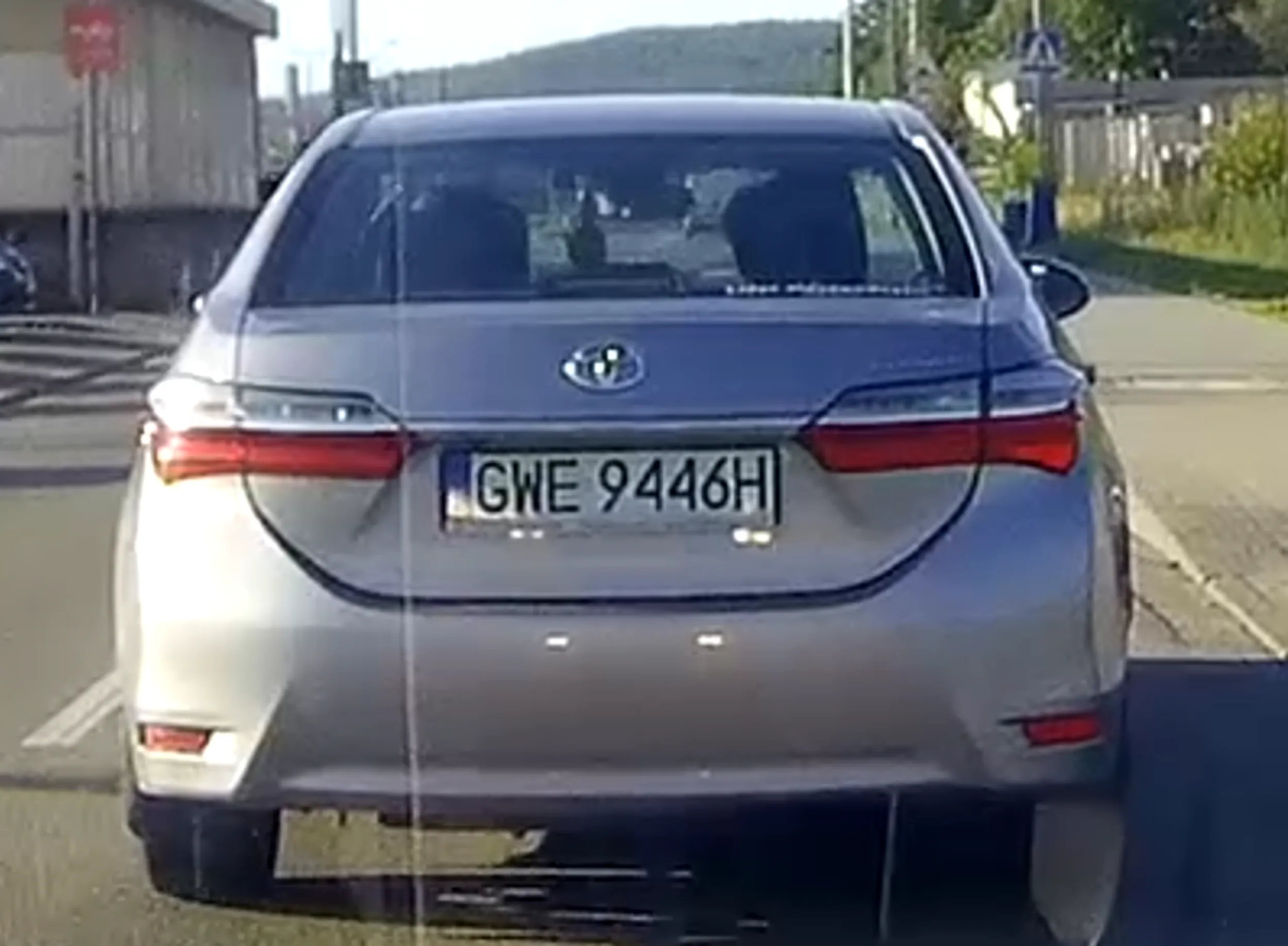 Srebrna toyota corolla. Starszy Pan szybko wyprzeda a potem gwałtownie hamuje prawie do 0, dodatkowo pokazuje palec (wskazujący).