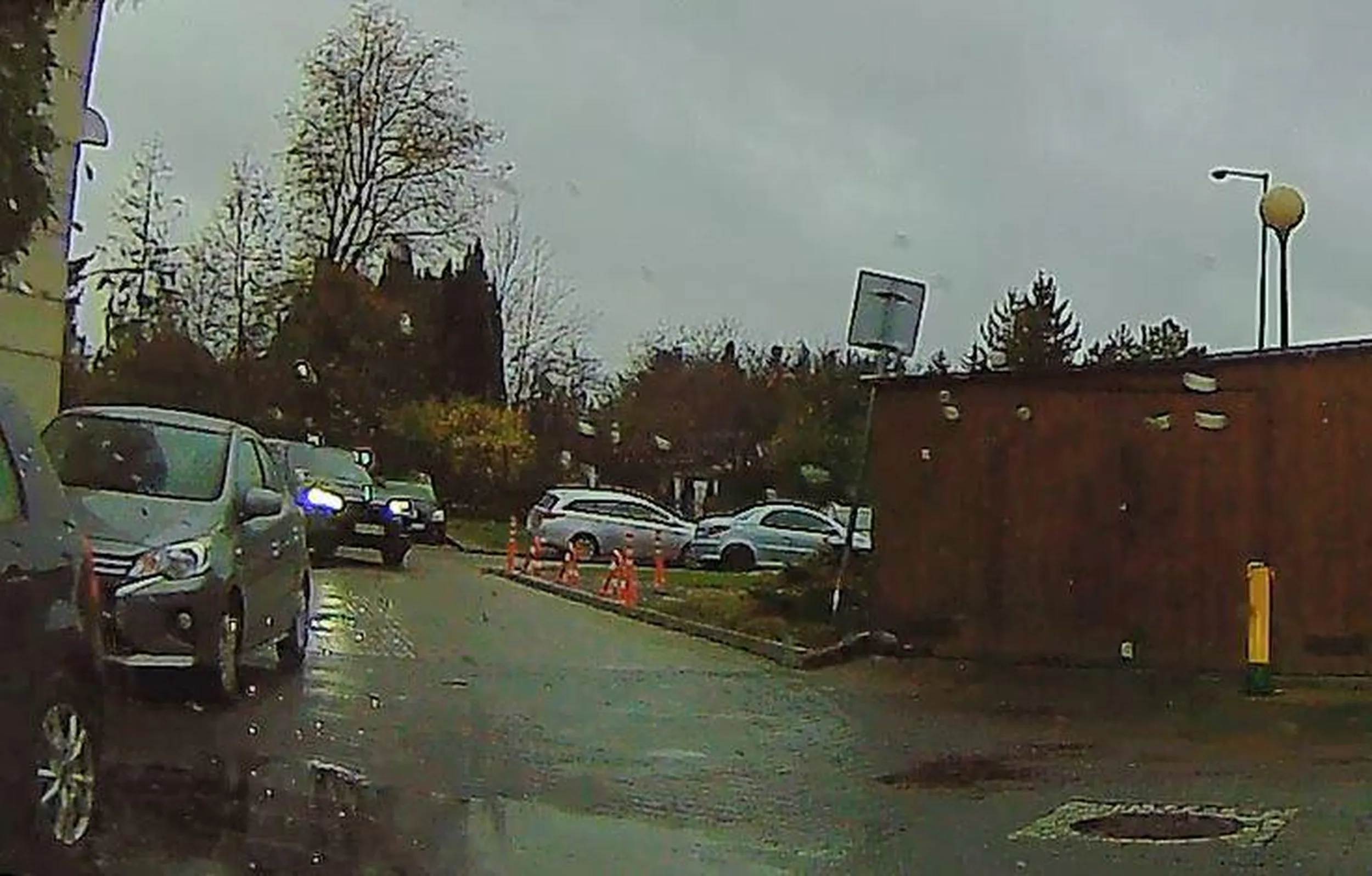 Ten niewysoki kolega w średnim wieku nie rozumie, że gdy zwężenie lub utrudnienie (tu: zaparkowane pojazdy) występuje po jego stronie, to musi zaczekać i ustąpić i nie może kontynuować jazdy, tym bardziej zajeżdżając drogę komuś jadącemu w przeciwnym kierunku prawidłowo po swojej stronie jezdni.