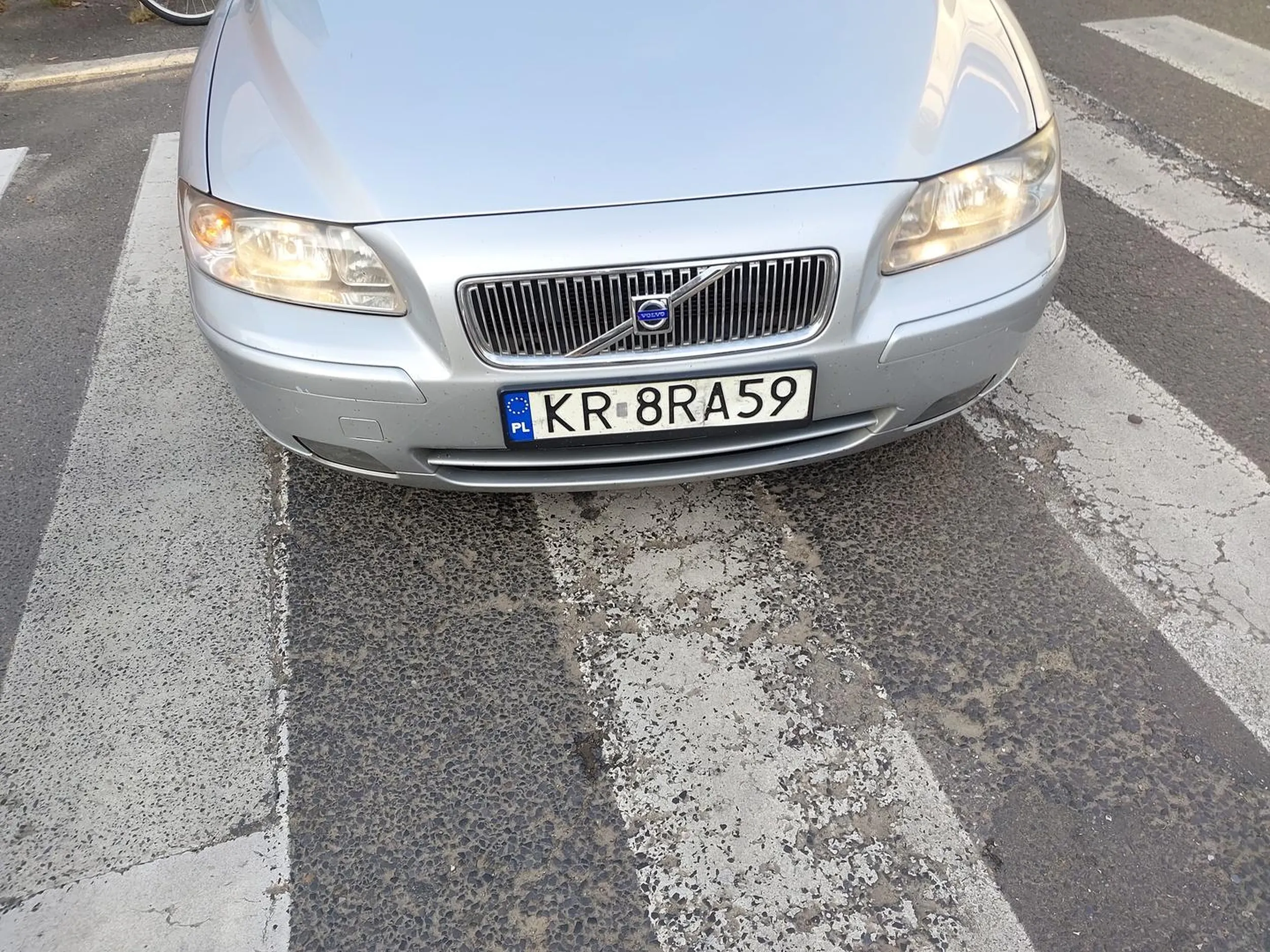 Kraków (2023-09-13 godz: 17:20) róg ulic: Limanowskiego i Krakusa. Kierowca skrecał z Krakusa w prawo w Limanowskiego. Wjechał poza połowę przejścia dla pieszych, a ja już chciałem wejść na przejście, nie zatrzymałem się i zacząłem wchodzić na przejście po czym on jeszcze podjechał ok pół metra i dopiero się zatrzymał. Następnie wszedłem na przejście stanąłem przed jego autem (srebrne Volvo) i popatrzyłem się na niego. Wówczas psychopata zaczął wymachiwać do mnie rękami, więc ja też machnąłem, że coś zrobił nie tak, wtedy otwiorzył szybę i zaczął krzyczeć wi ęc mówię, że wymusił pierwszeństwo pieszemu. Po krótkiej kłótni, otworzył drzwi i częściowo wyszedł z auta, wyjmując coś ze schowka w drzwiach. Gdy podniósł rękę okazało się, że ma w ręćę gaz i zaczał machać tak, że zagroził mi użyciem gazu przeciwko mnie. Wówczas krzyknałem że zaraz moge wezwac Policję i zrobiłem zdjęcia, które załaczam. Rozważe teraz czy zgłosić to na Policję - to jest beznadziejny prostak, który powinien iść za 