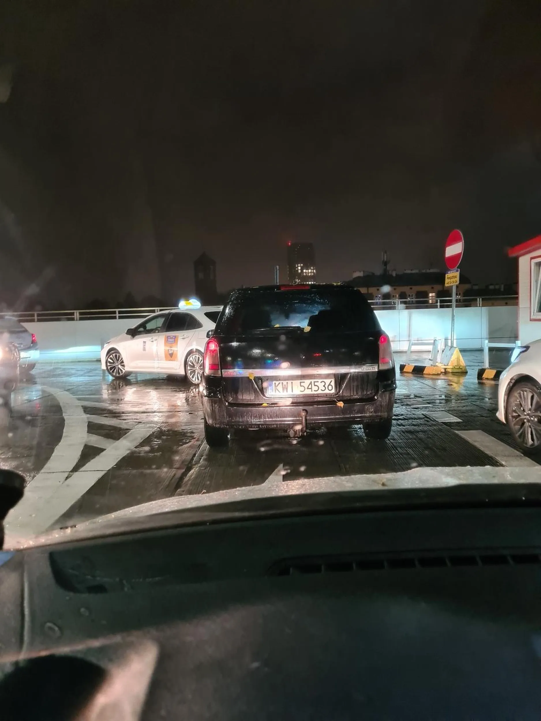 Pani kierowca zawraca na środku wjazdu do parkingu i blokuję rucy