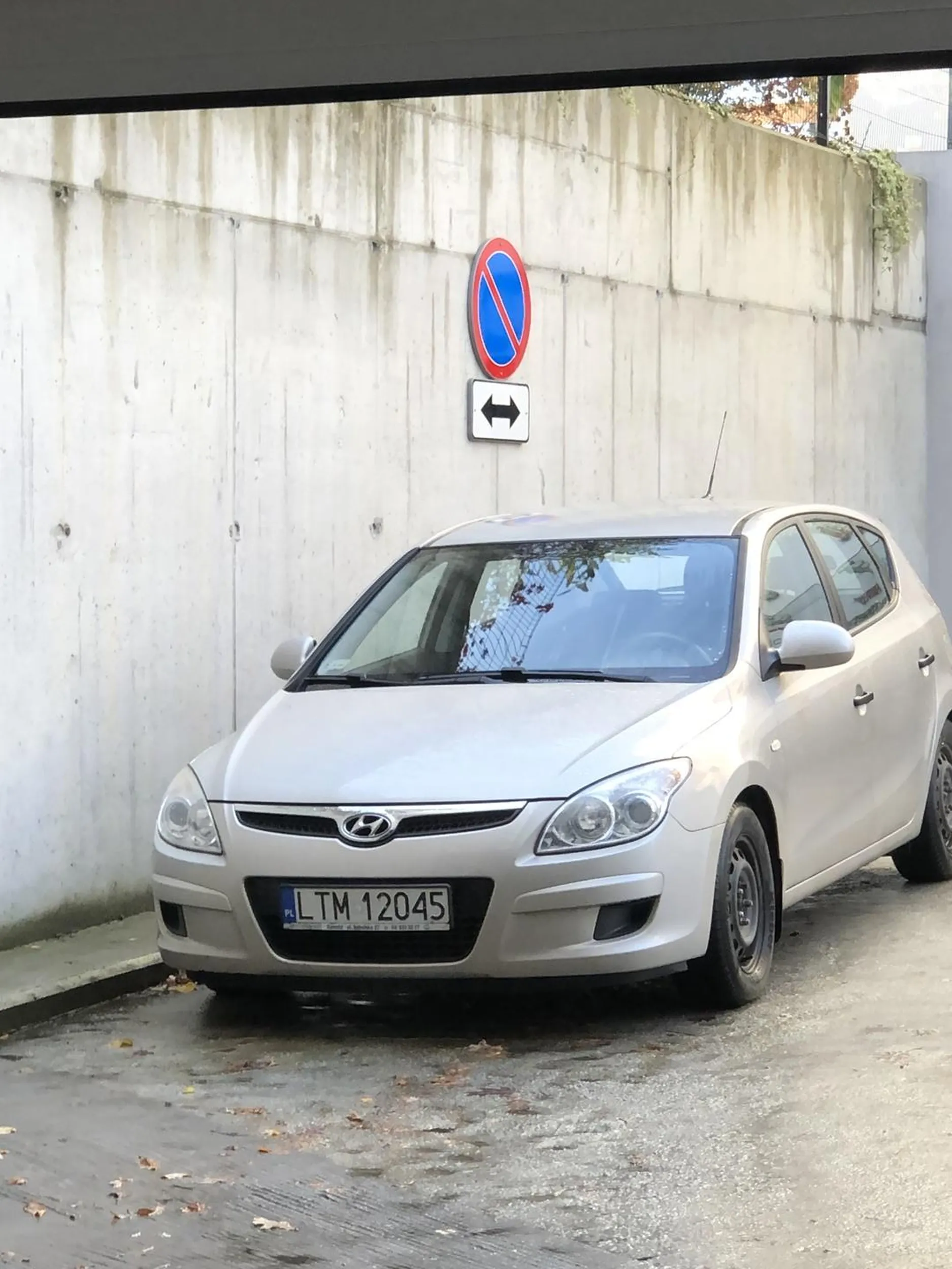 Kierowca zastawia bramę garażowa. Miejsce parkingowe zrobił sobie w strefie zamieszkania, na rampie garażowej na drodze przejazdowej  i żeby było mało pod znakiem…