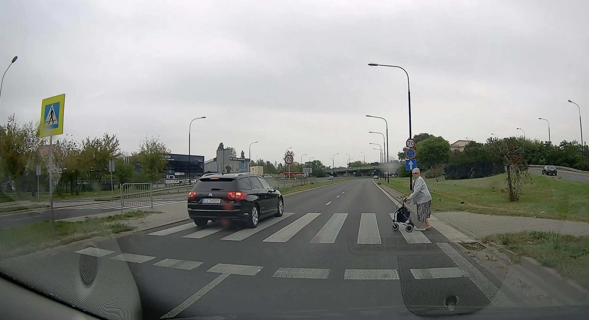 Bandyta za kółkiem, który omija przed przejściem o ruchu niekierowanym i o mały włos nie potrąca pieszego na pasach.