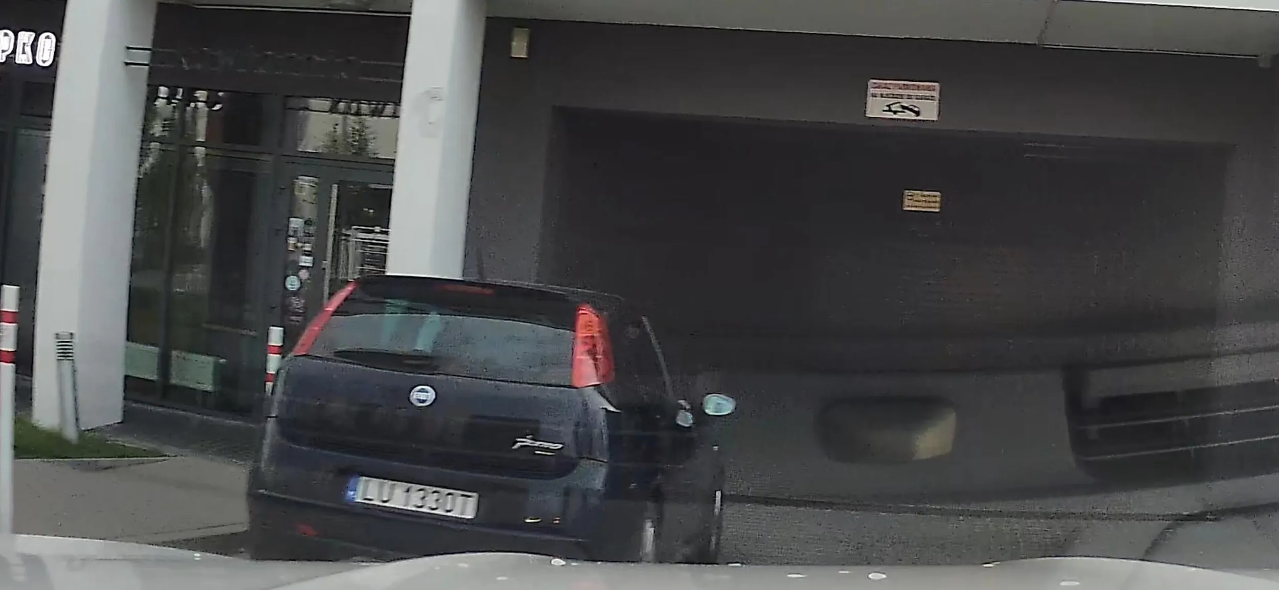 Kierowca parkuje na zakazie, we wjeździe do garażu