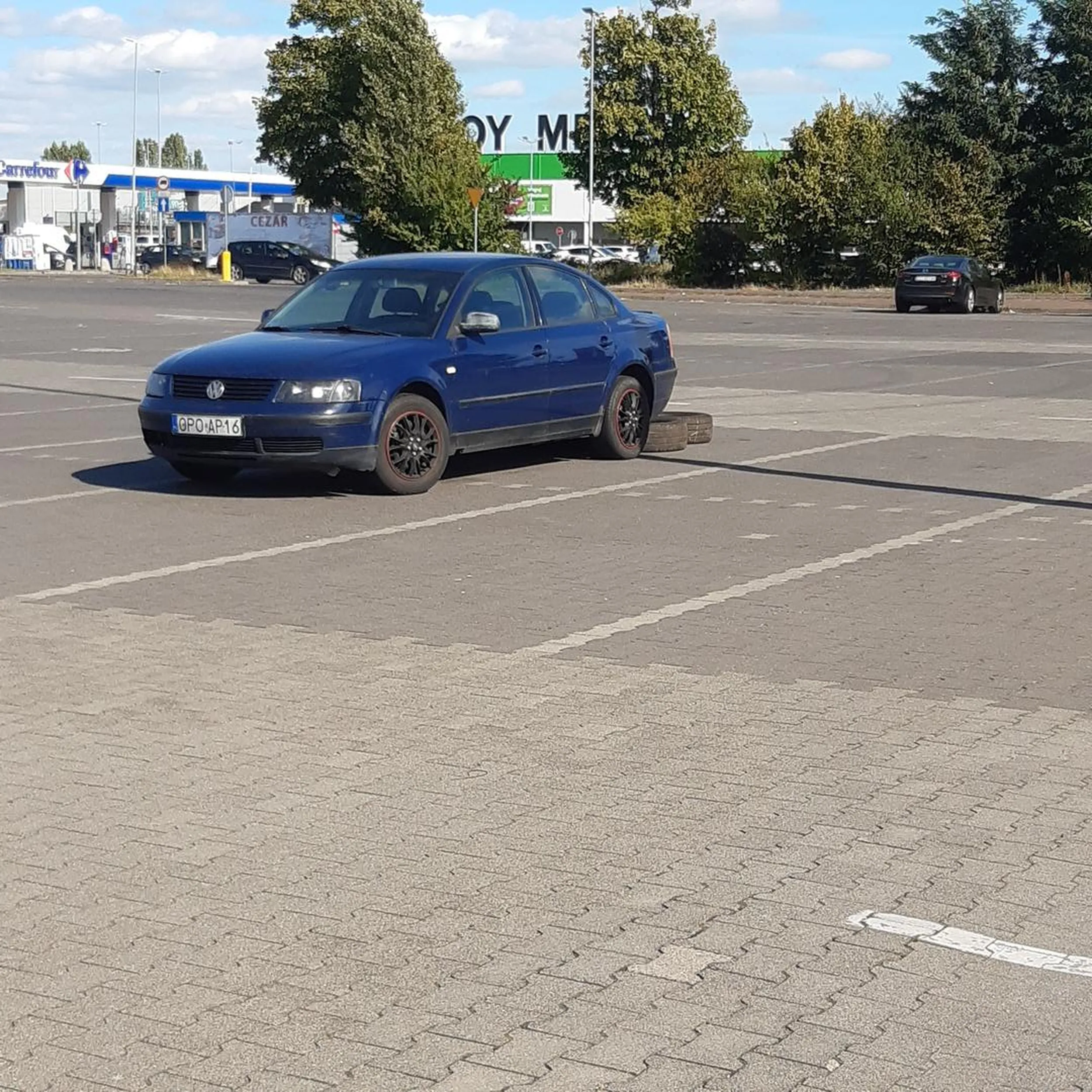 Stoi na parkingu galerii handlowej z oponami z tyłu