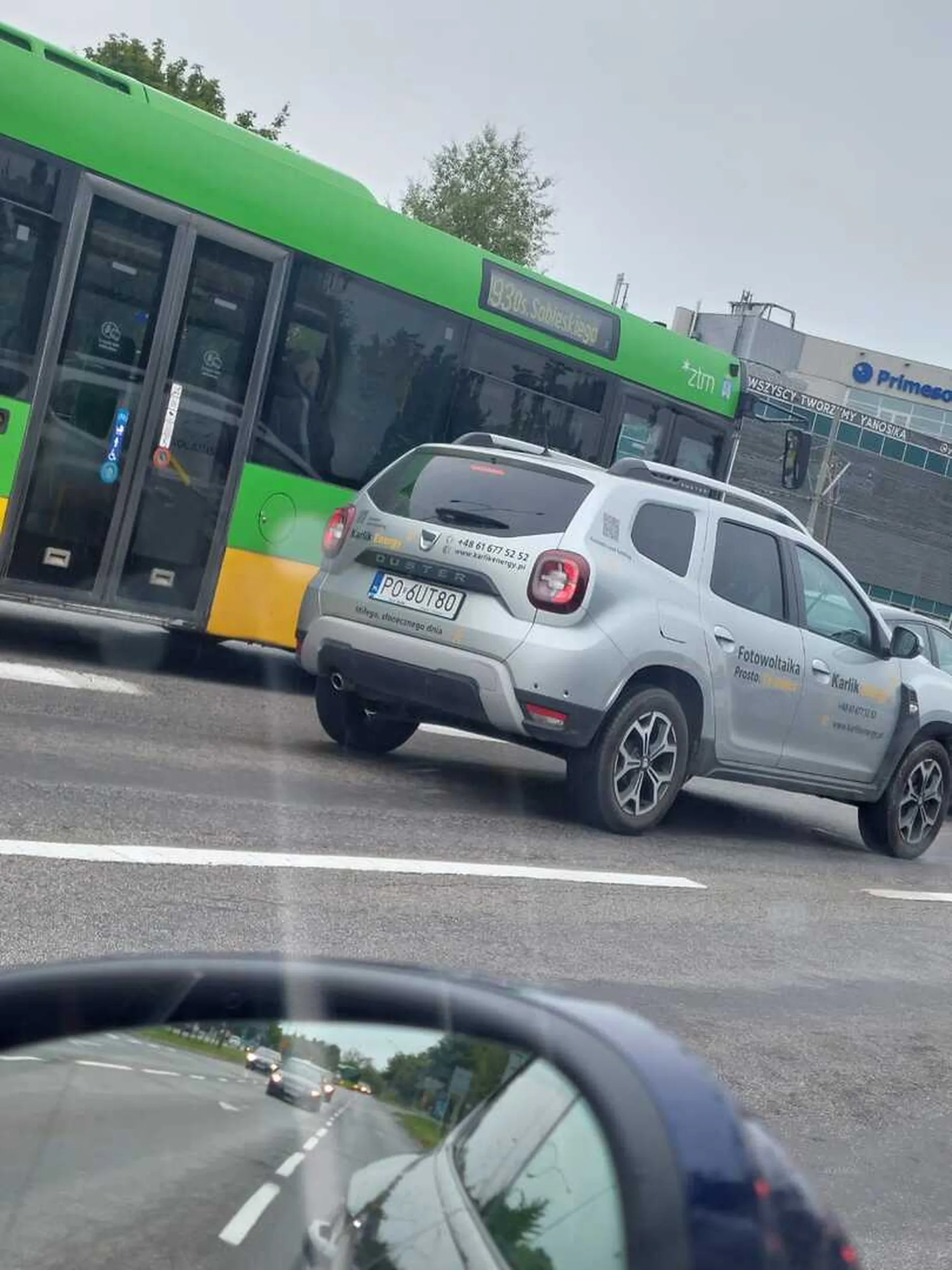 Ambitny kierowca firmowej Dacii duster, zmienia pasy ruchu bez zerkania w lusterko, zawraca na czerwonym świetle.