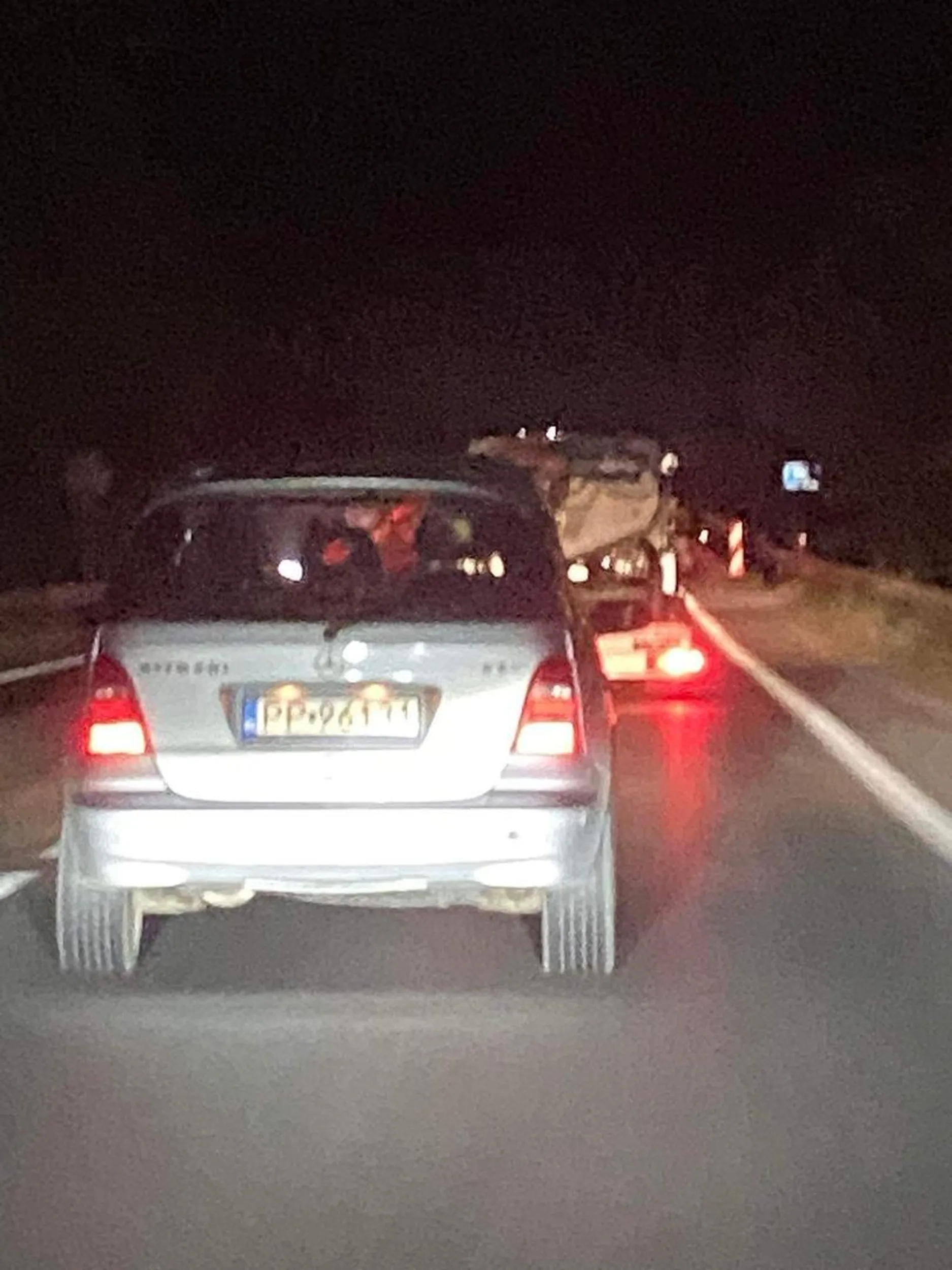 Kierowca całą drogę korzysta ze smartfona trzymając go w ręce.