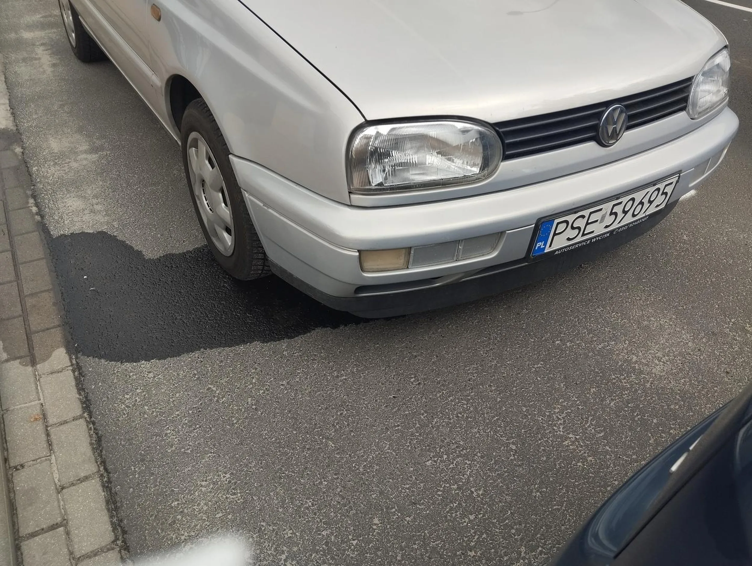 Z samochodu osobowego wylewa się olej