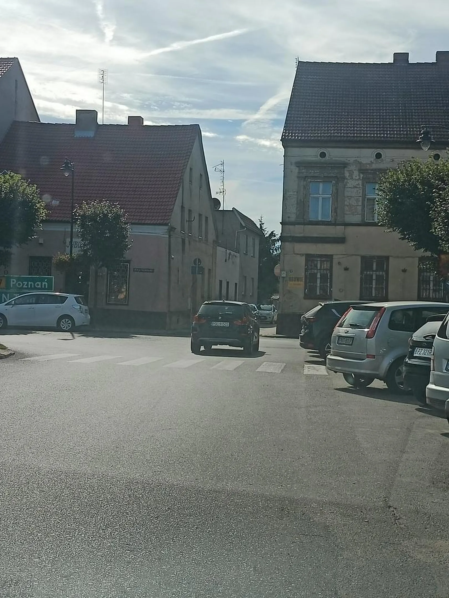 Brak miejsca parkingowego więc kierowca na awaryjnych zostawił auto zaraz za przejściem dla pieszych na środku pasa zastawiając inne pojazdy zaparkowane prawidłowo