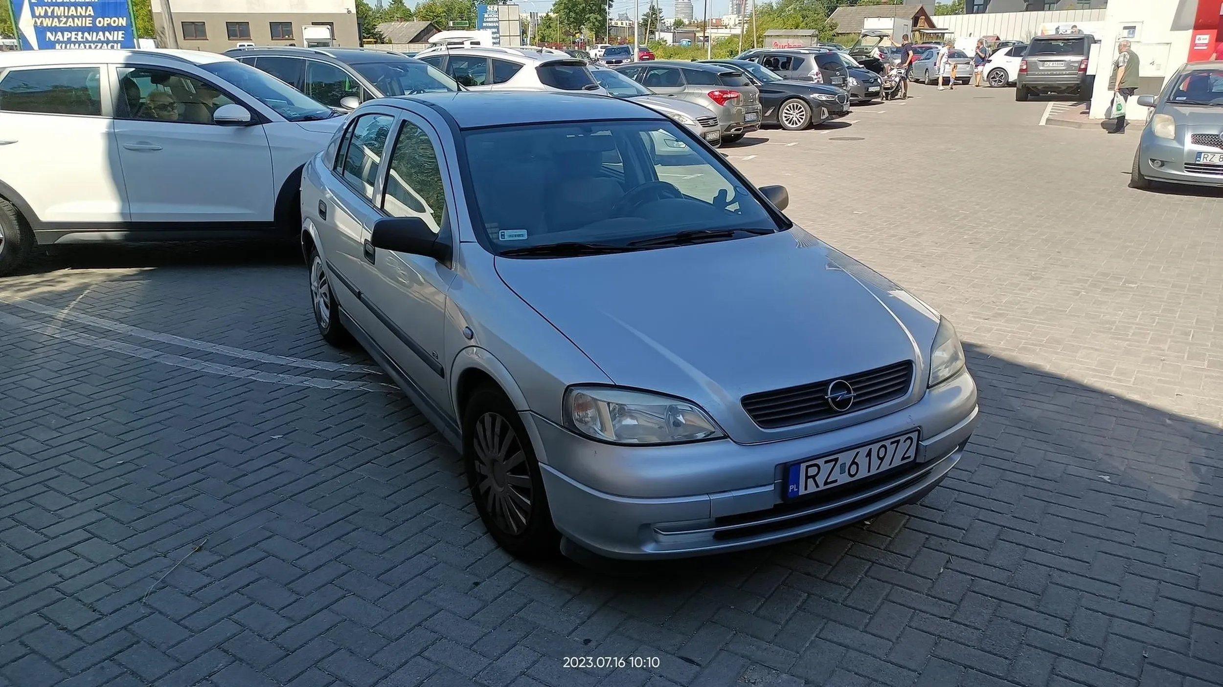 Centralnie na wjeździe na parking.