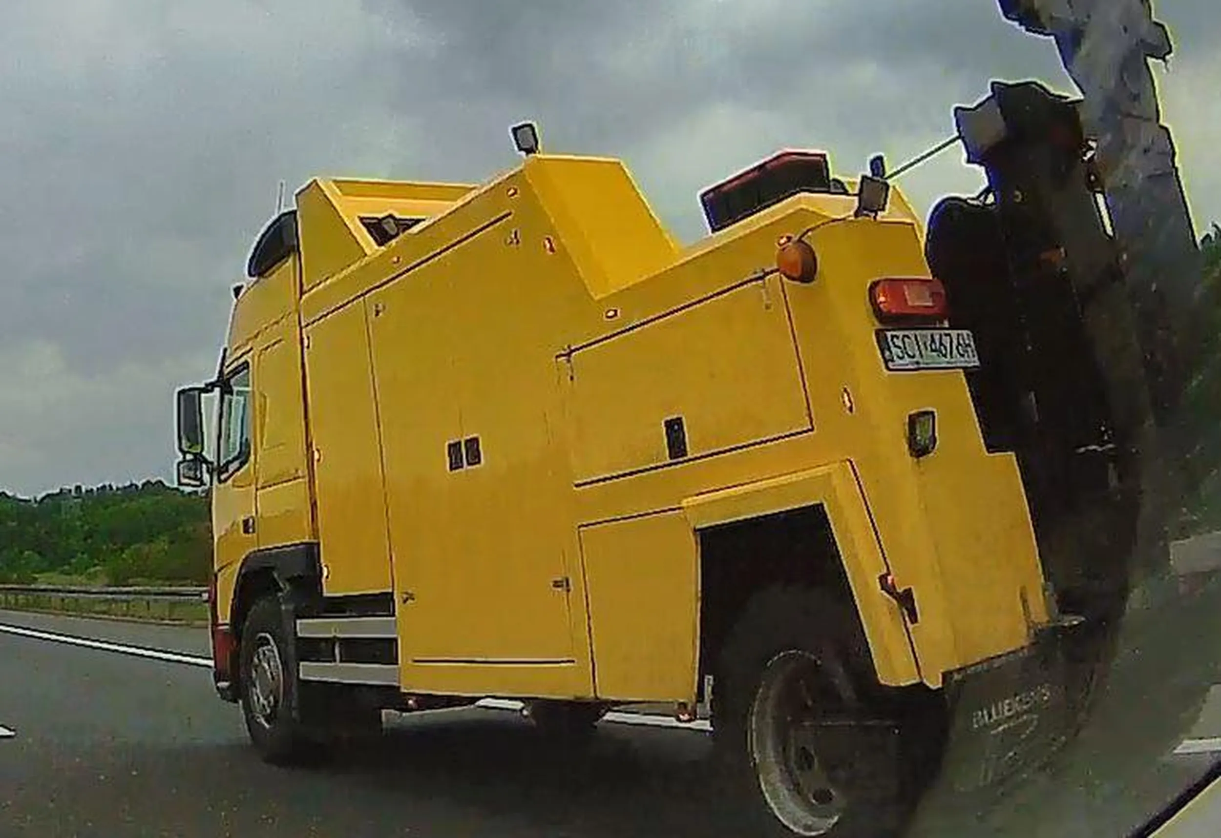 Oto pojazd pomocy drogowej, ciągnący zderzak służby drogowej wykorzystywany podczas prac na drogach szybkiego ruchu/autostradach - zderzak ma niesprawne oświetlenie i znak nakazujący omijać go z prawej strony. Bez komentarza.