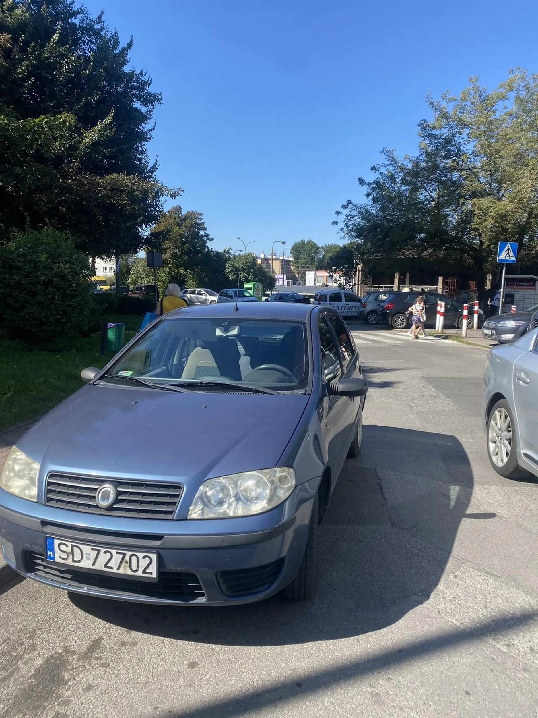 Samochód zaparkowany na jednym pasie ruchu. Oznacza to, że inne samochody muszą wymijać ten pięknie zaparkowany samochód. Do tego auto zasłania przejście dla pieszych, które znajduje się za samochodem jakieś 2 metry. Samochód został zaparkowany w ten sposób, aby Pani nie musiała iść15 kroków z miejsca parkingowego, najchętniej zaparkowałaby pod samym targiem, ale niestety nie można, dlatego Pani wybrała nielegalne miejsce, aby nie musieć robić nawet 5 kroków. Pani która parkowała ten samochód doskonale widziała, że są robione zdjęcia. Następnym razem polecam się odezwać, bo skoro miała pani tyle odwagi, żeby tak bezczelnie zaparkować, to też proszę mieć odwagę podejść :)