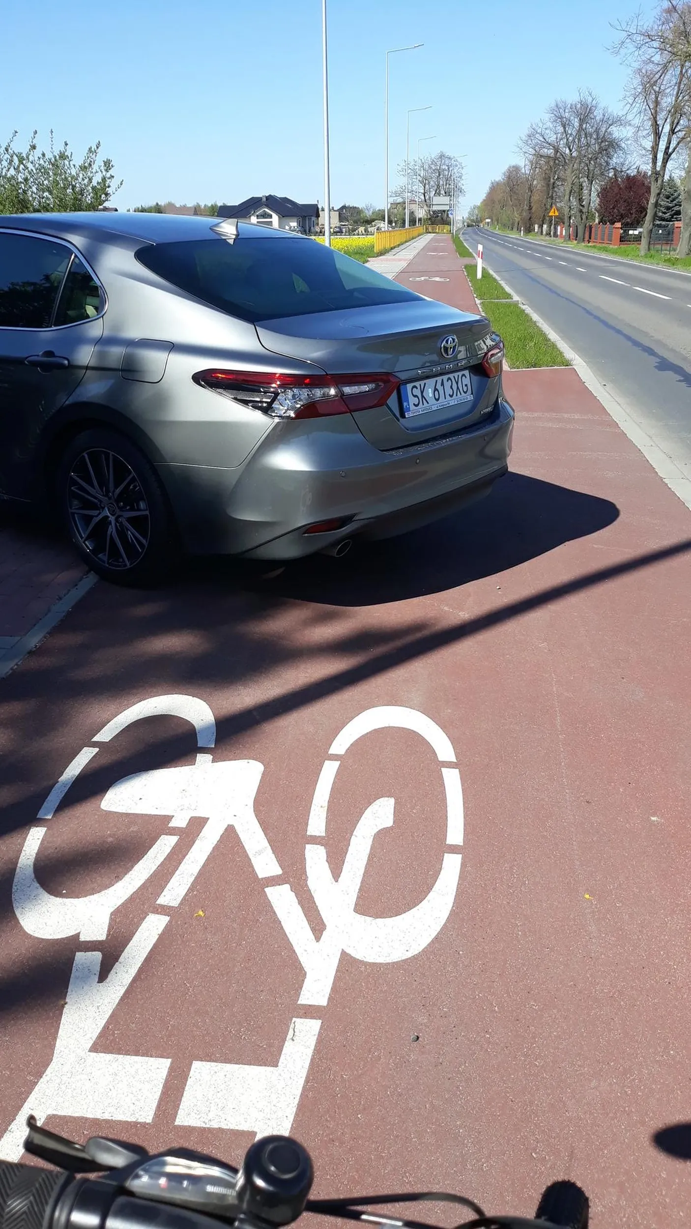 Parkowanie na chodniku, parkowanie na drodze dla rowerów, bardzo niebezpieczna sytuacja dla pieszych i rowerzystów chcących ominąć przeszkodę przy bardzo ruchliwej głównej drodze, narażając zdrowie a nawet życie uczestników ruchu.