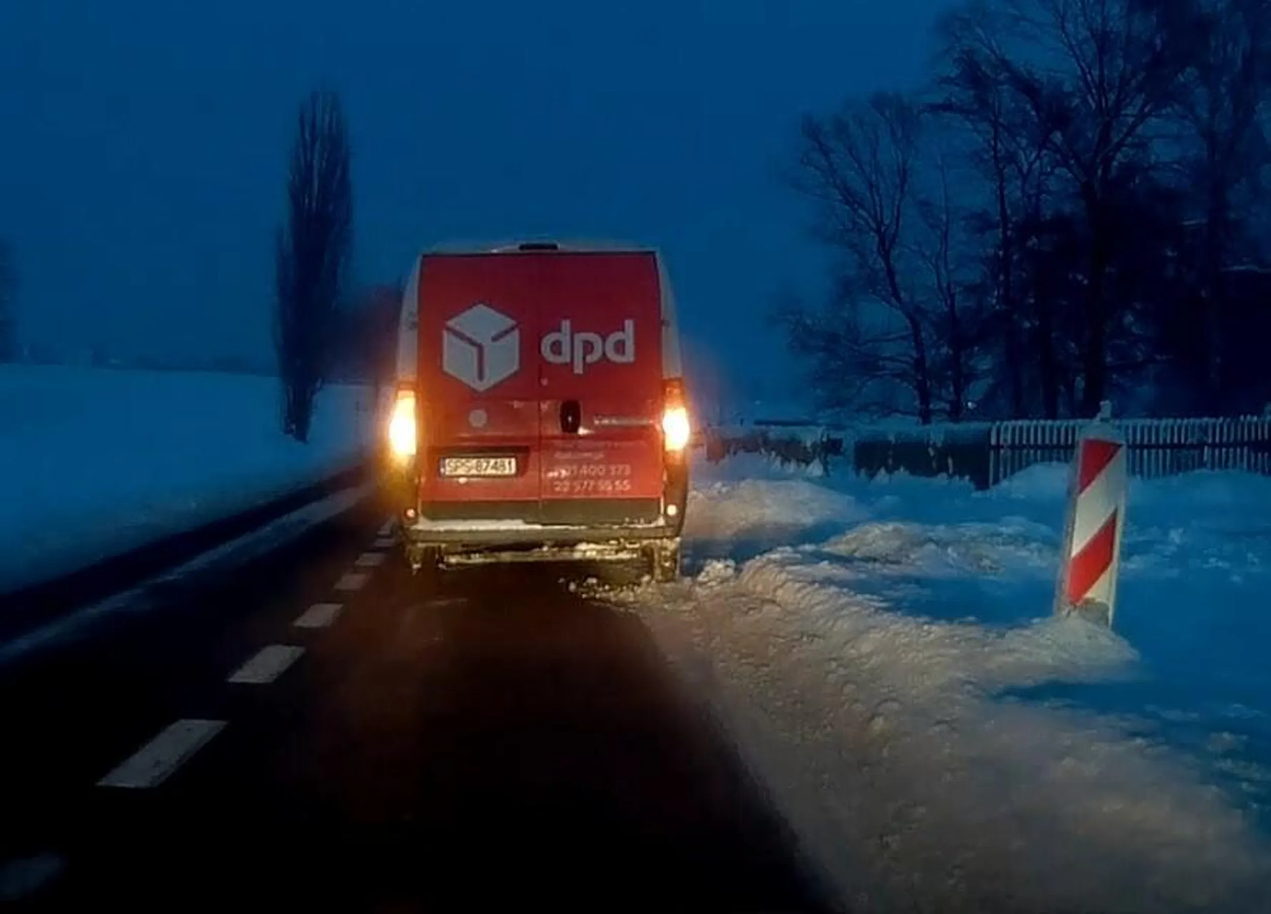 Kureier parkuje na środku drogi pomimo odśnieżonego zjazdu
