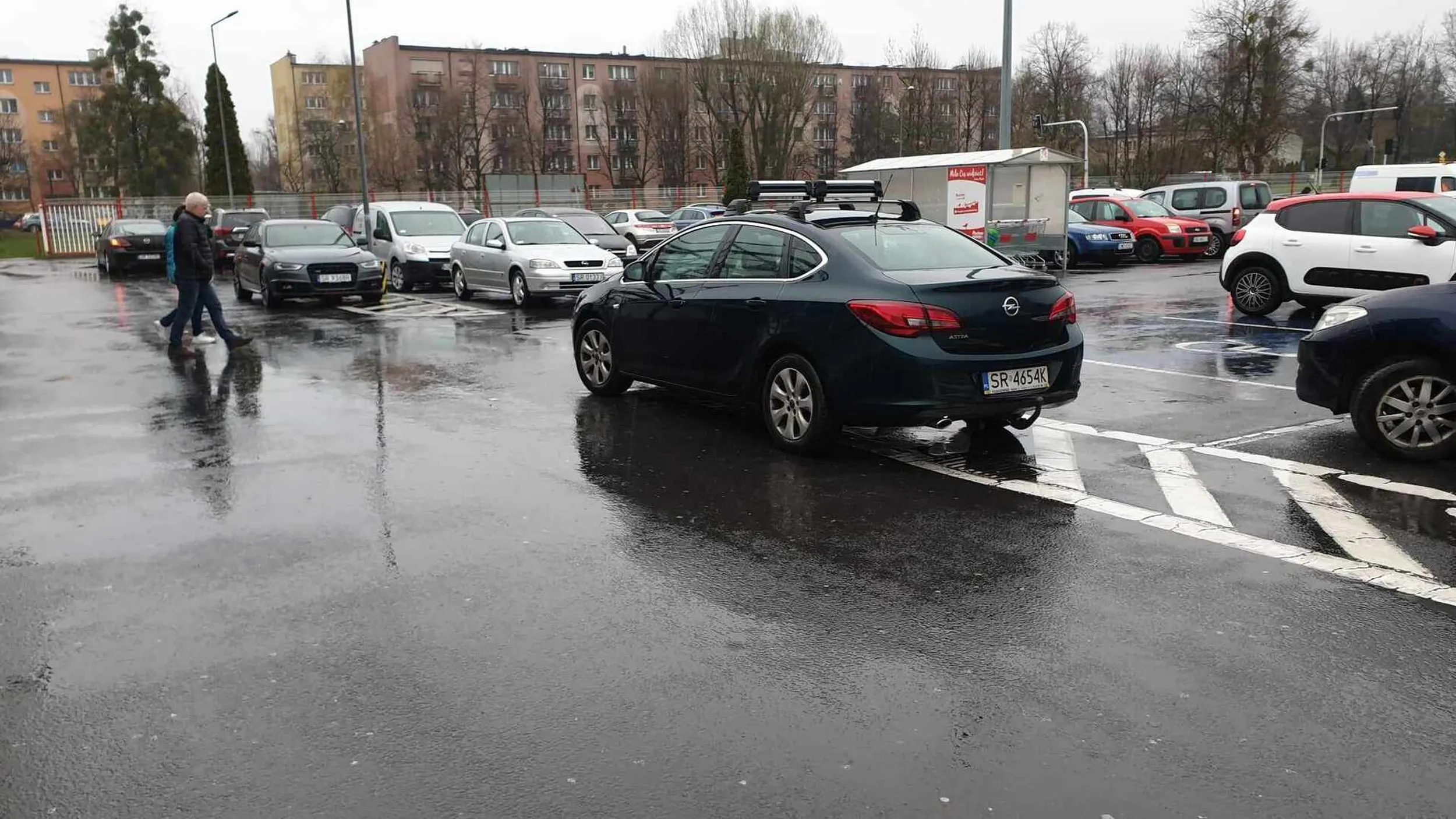 Cham i prostak, który gdyby mógł to wjechałby do sklepu. Parkuje samochód w sposób, który utrudnia pozostałym uczestnikom ruchu poruszanie się po parkingu.
