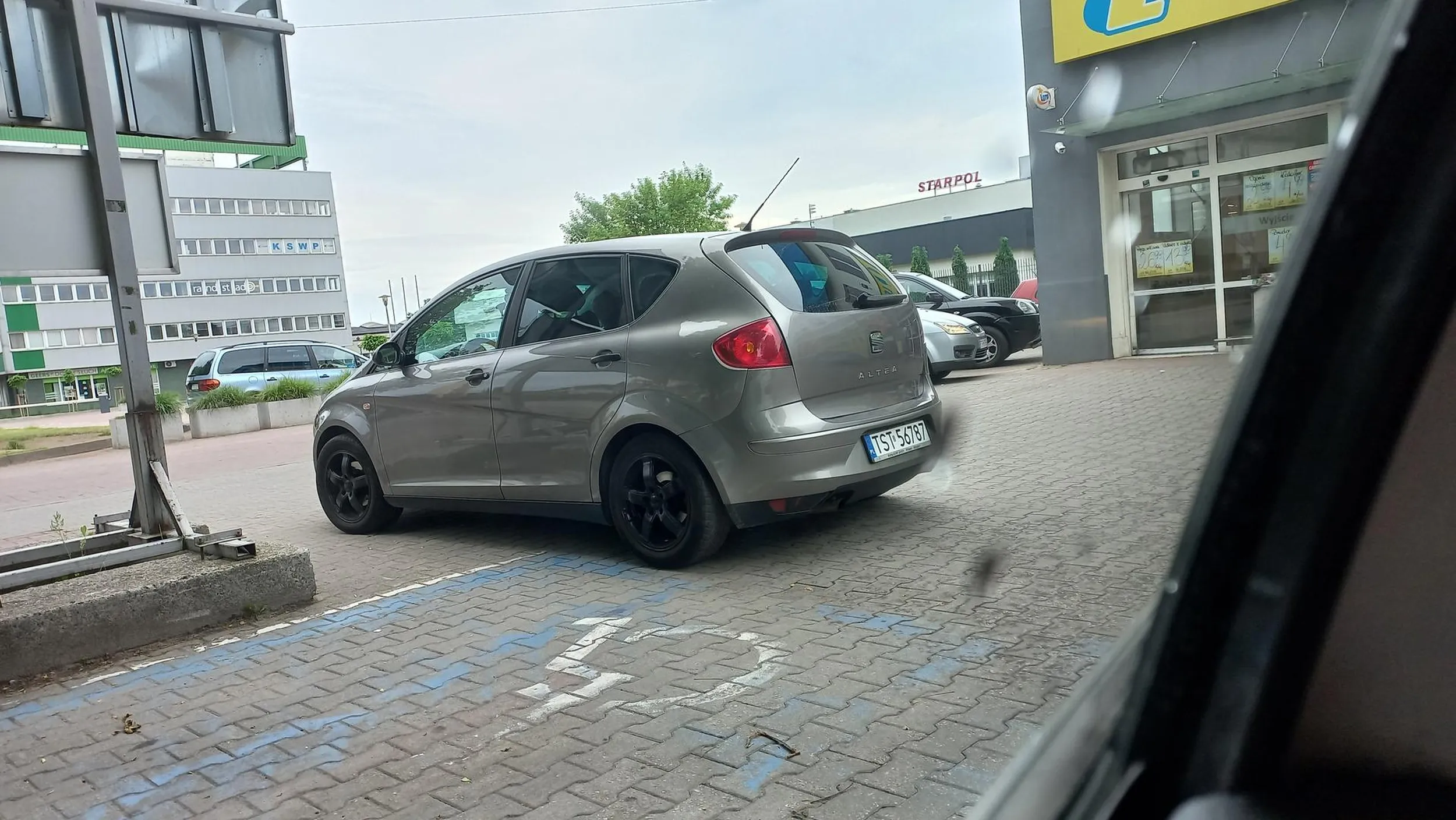 Kierowca nie potrafi normalnie zaparkować pomimo dużo wolnych miejsc parkingowych, blokuje miejsce parkingowe dla niepełnosprawnych.