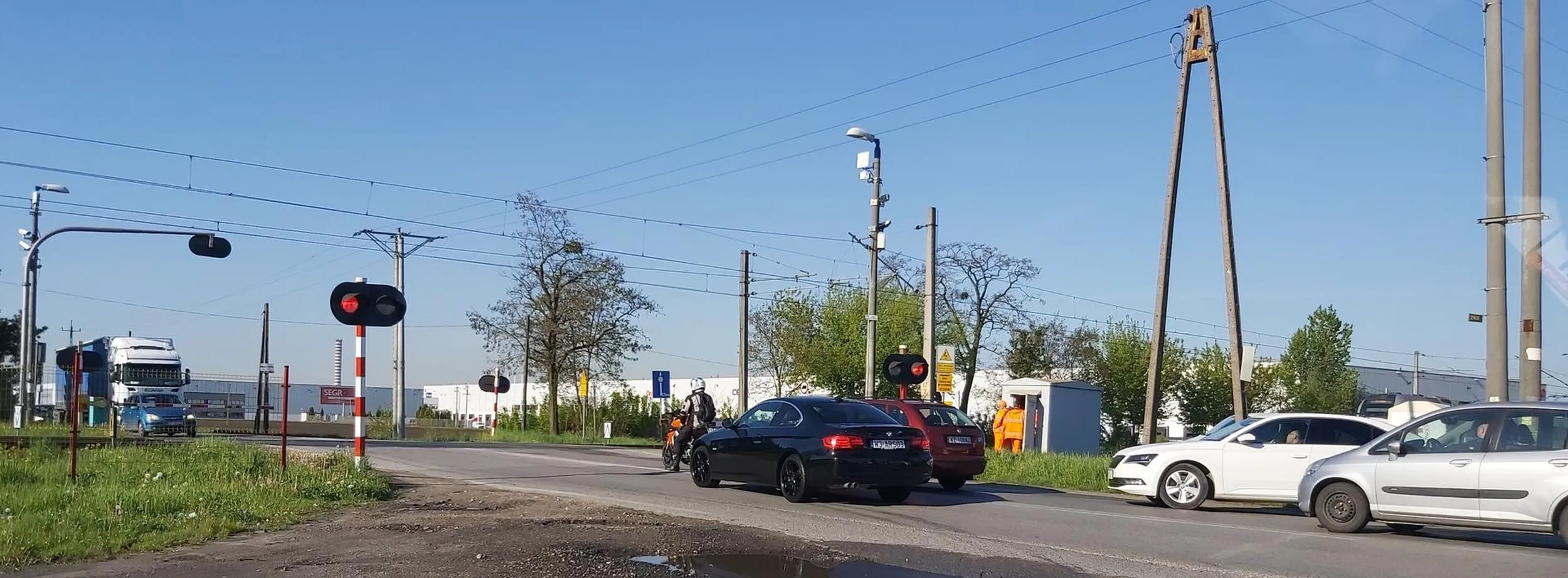 Nie wiem, czy właściciel BMW wie, co oznacza "arse", ale to słowo trafnie go opisuje. Najpierw lewym pasem wyprzedza dłuuugą kolejkę do skrzyżowania przed przejazdem kolejowym, potem skręca w lewo i nadal będąc na lewym pasie ustawia się do otwarcia przejazdu.