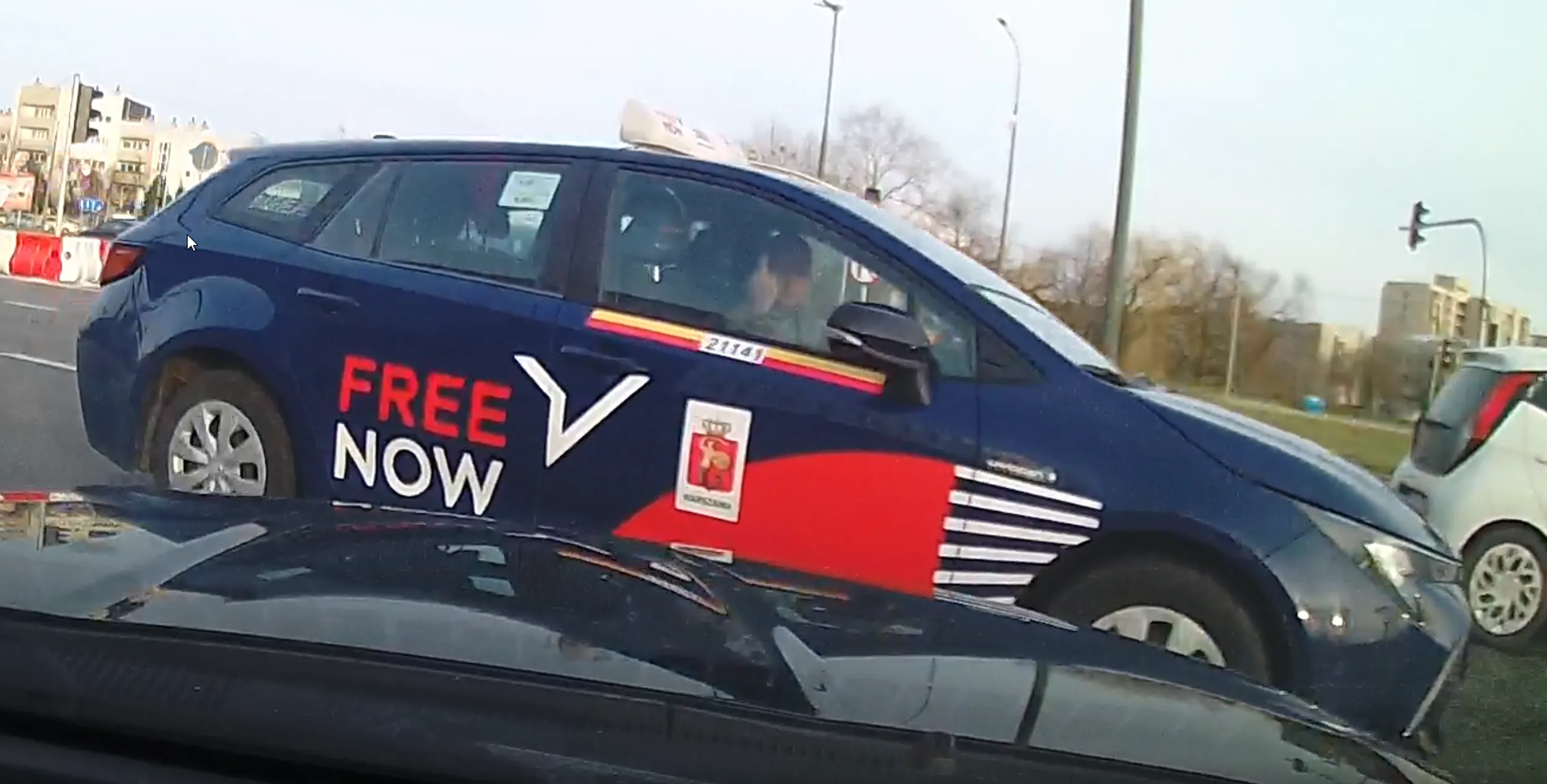 Pan z taxiarz z Toyoty nie dość, że skręca w lewo z pasa do jazdy na wprost, to jeszcze wymusza pierwszeństwo. W dodatku środkowy palec mu chyba bardzo śmierdzi i musi jeździć z uniesionym. Burak bez prawka.