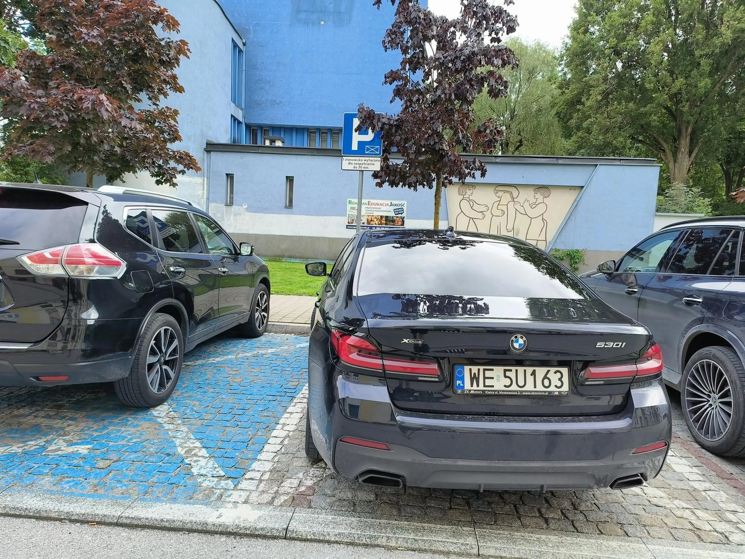 Niepoprawne parkowanie, częściowo na miejscu dla inwalidów