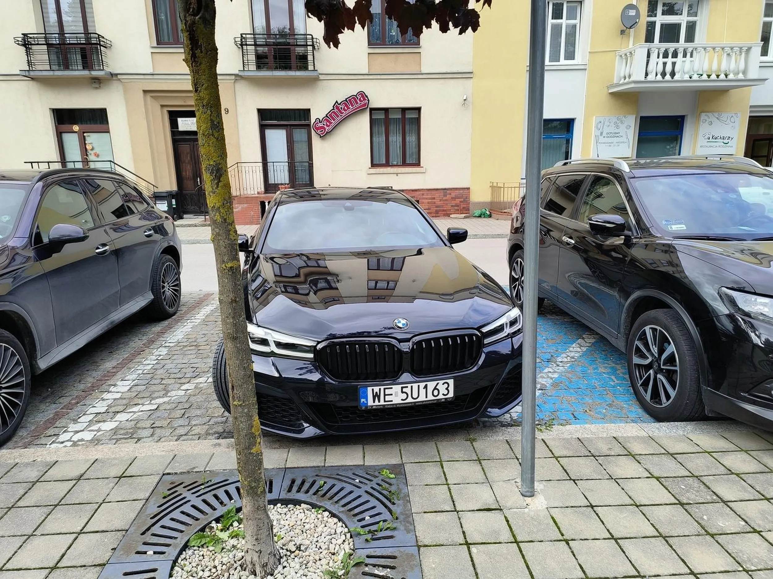 Niepoprawne parkowanie, częściowo na miejscu dla inwalidów