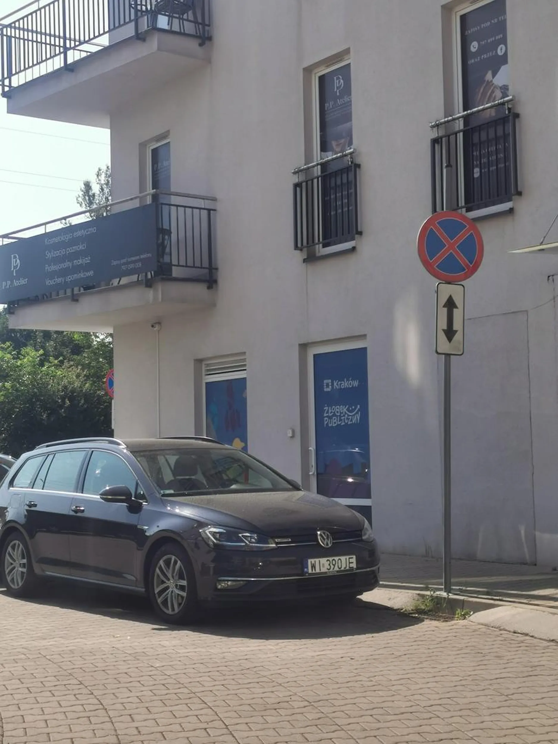 Przy szlabanie na zakazie, przed łukiem i blokując połowę wyjazdu z osiedla