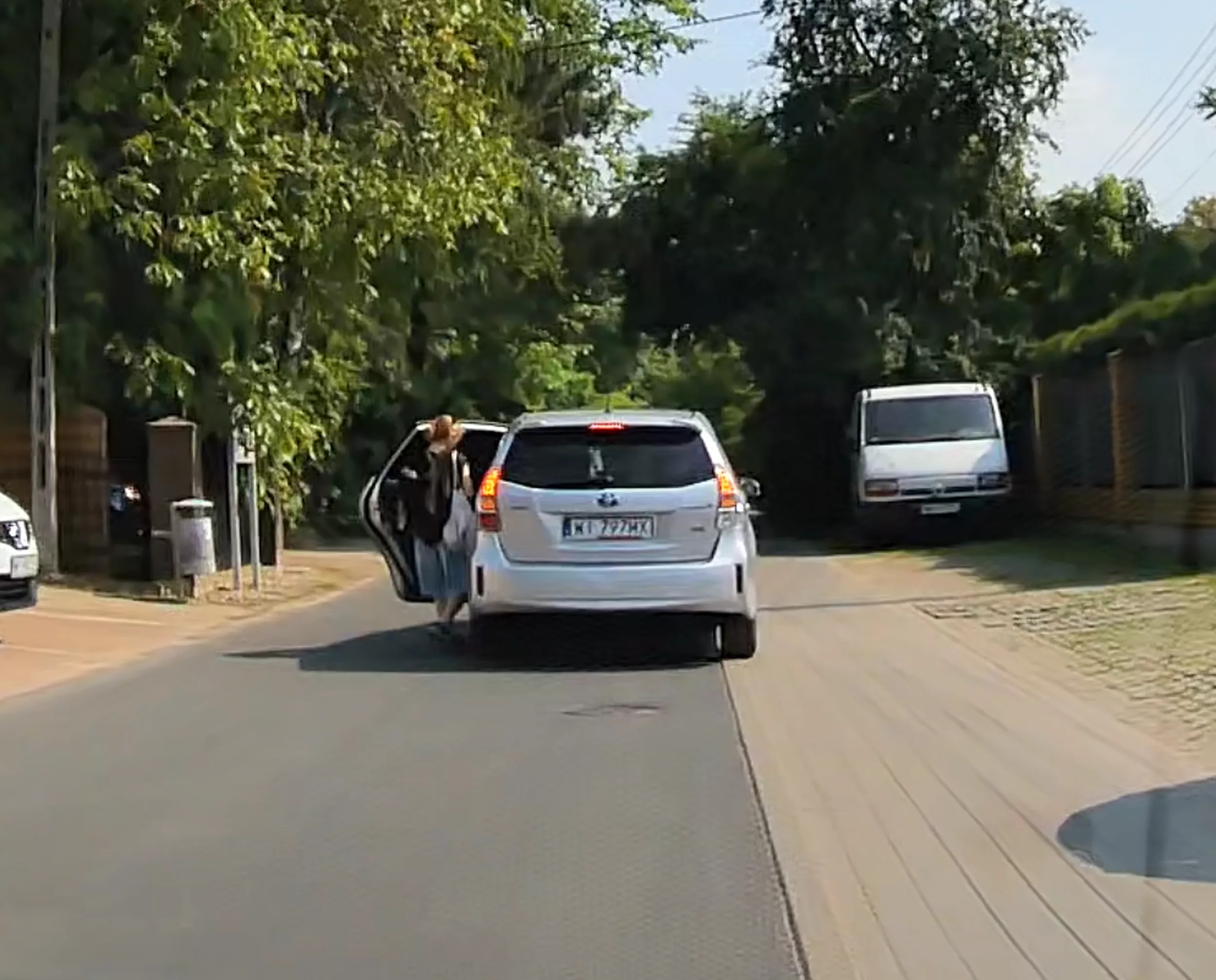 Zatrzymuje się na środku ulicy, aby zabrać pasażera, podczas gdy zaraz obok jest parking.