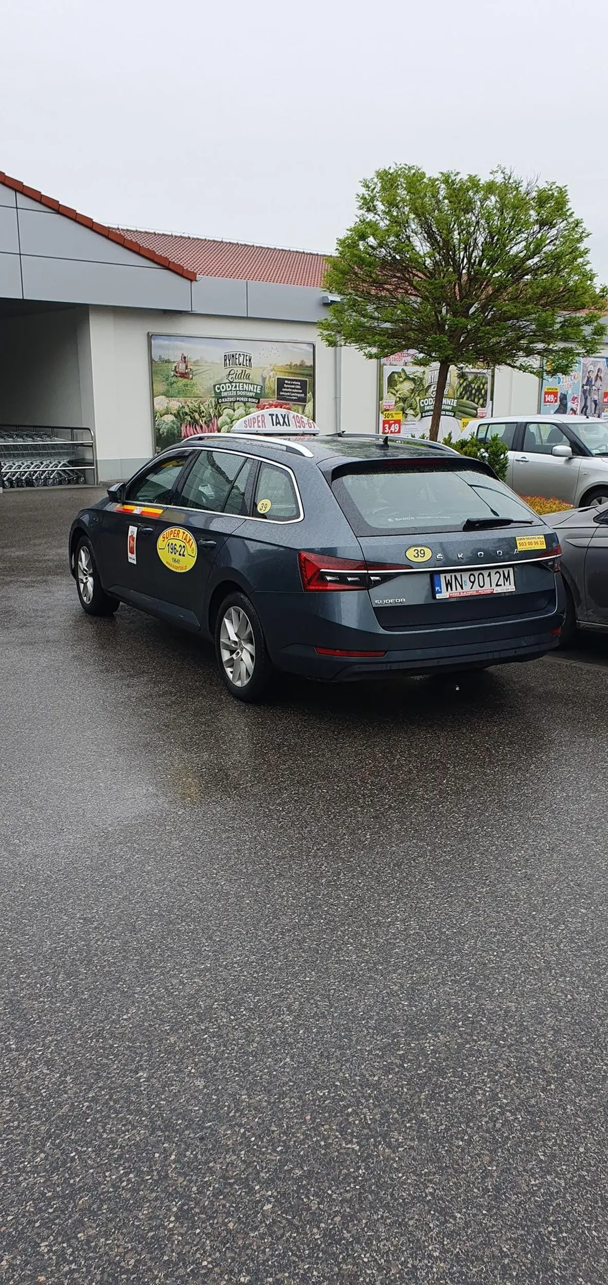 6 rano.Parking pod sklepem. 3 miejsca zajęte, a kierowca stoi na przejeździe, aby tylko najbliżej wejścia do sklepu. Jak widać tylko ns chwilę bi szyb nie zamykał mimo że kropiło.