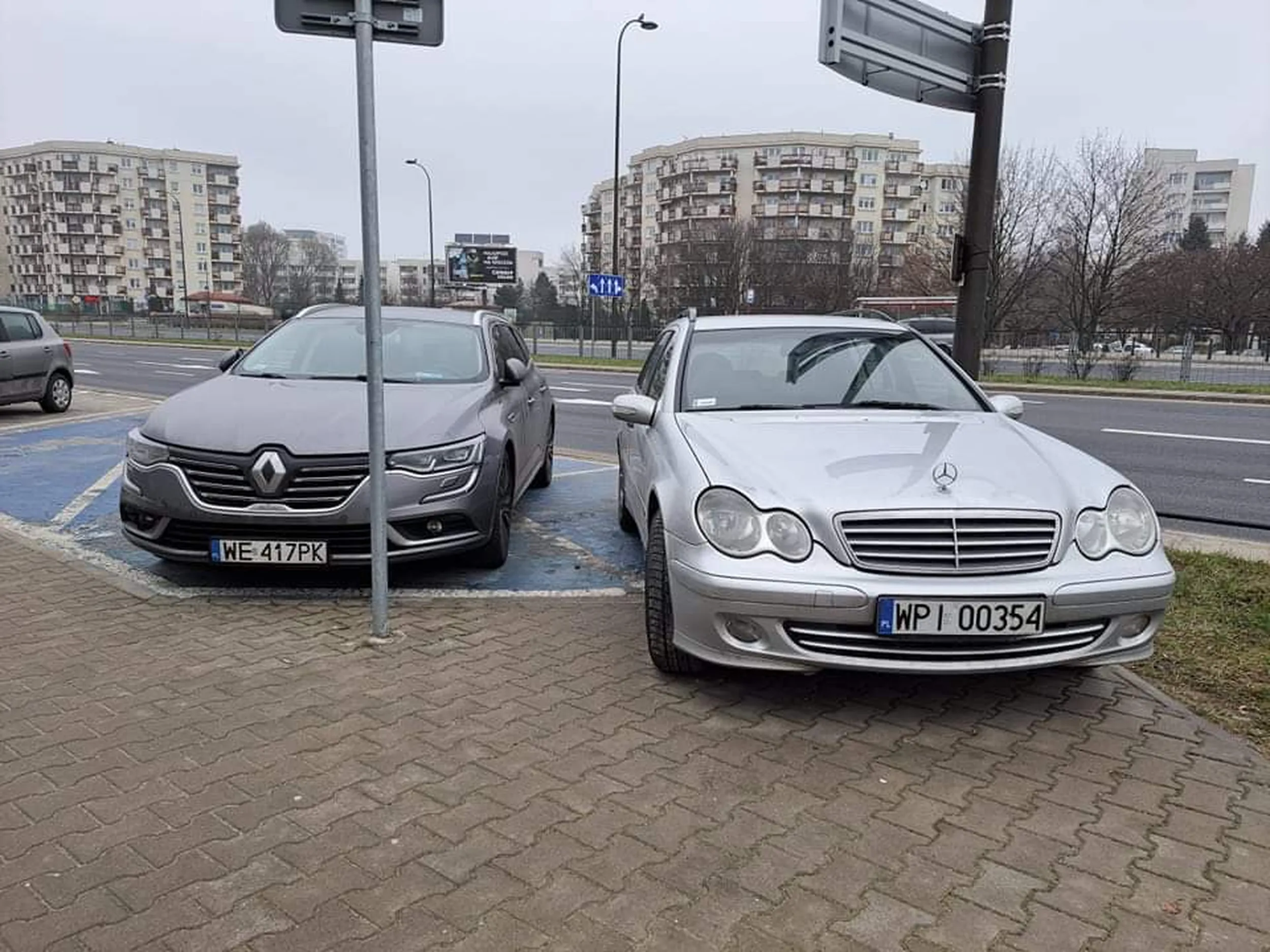 Kierowca Mercedesa to ignorant pierwszej wody.  Zablokował właścicielce na wózku swobodne wejście do auta (Renault) dodatkowo wjeżdżając na chodnik.