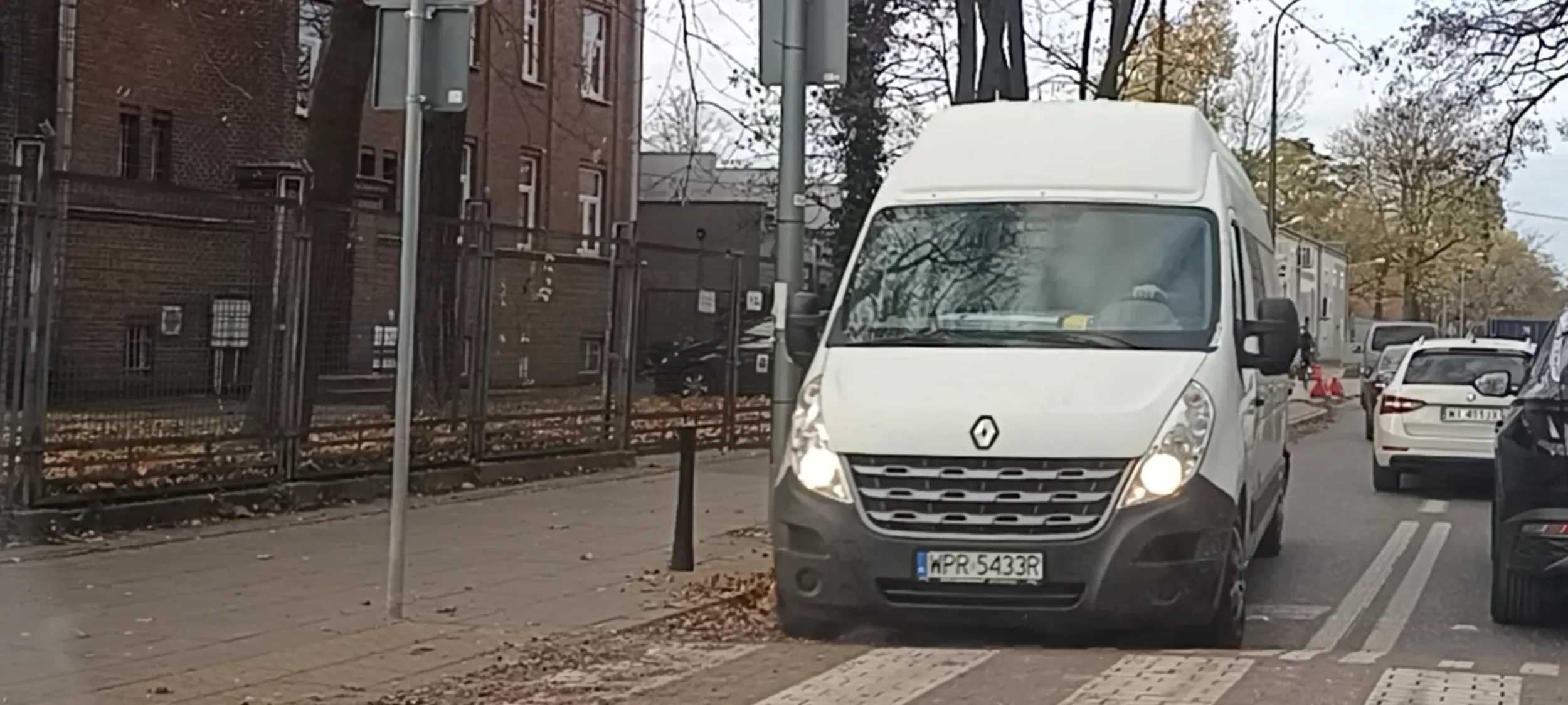 Cham z tego dostawczaka jedzie ulica jednokierunkową pod prąd i aby uniknąć zderzenia z samochodami wjeżdża na chodnik prawie potrącając pieszego.