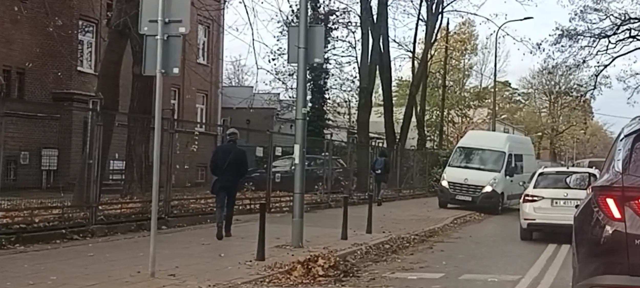 Cham z tego dostawczaka jedzie ulica jednokierunkową pod prąd i aby uniknąć zderzenia z samochodami wjeżdża na chodnik prawie potrącając pieszego.