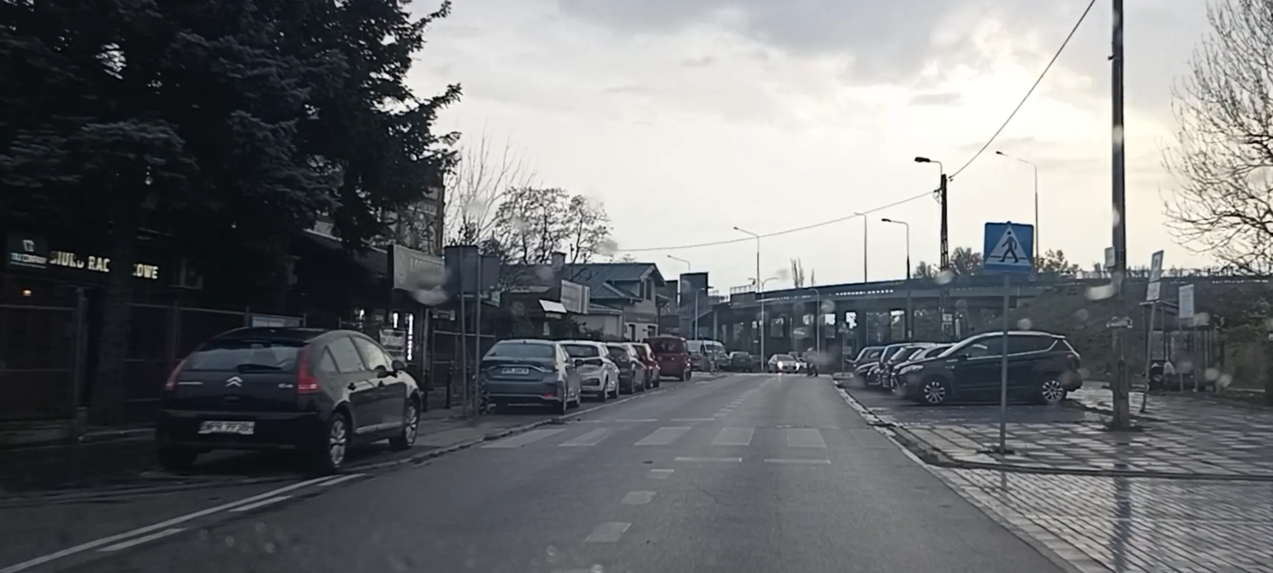 Zasłania widoczność przed przejściem dla pieszych i parkuje  na chodniku na skrzyżowaniu.