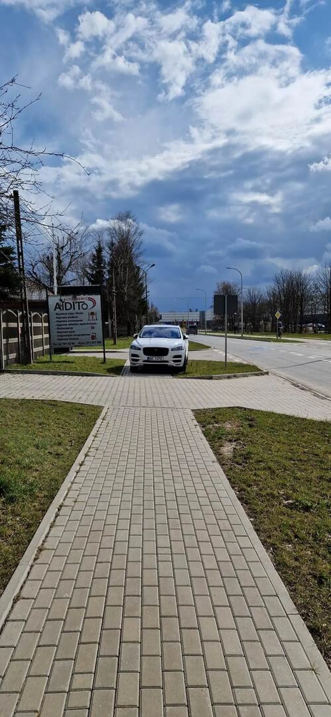Kierowca woli zastawić cały chodnik niż wjechać na teren widocznego serwisu do którego zapewne przyjechał.