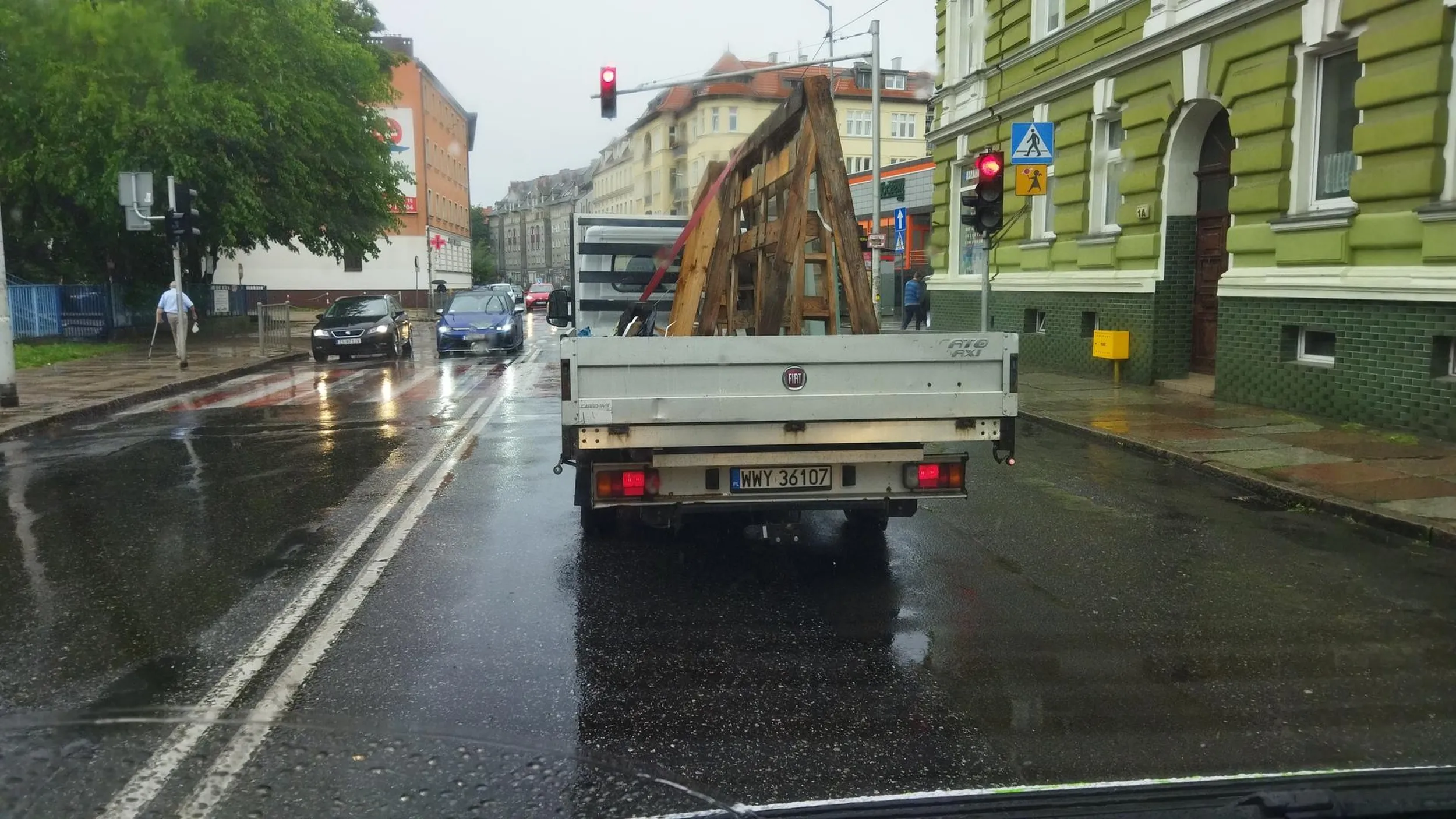 Kierowca z całym impetem wjeżdża w kałuże, choć widzi że przy przejściu czekają piesi.