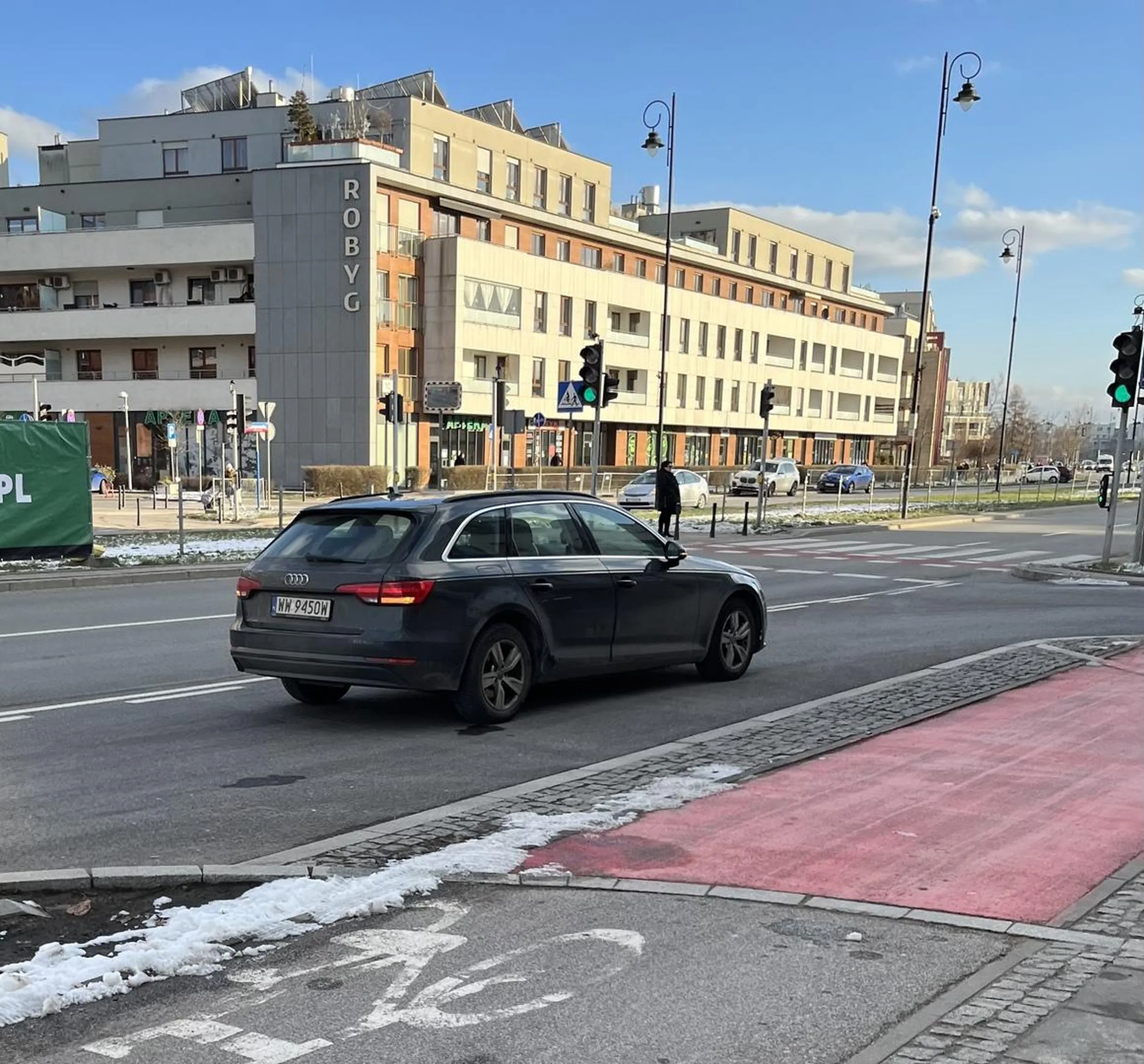 Kobieta stoi na wjeździe do garażu blokując tym samym wjazd do niego przy okazji prowadząc rozmowę przez telefon. Nie polecam kierującej pojazdem.