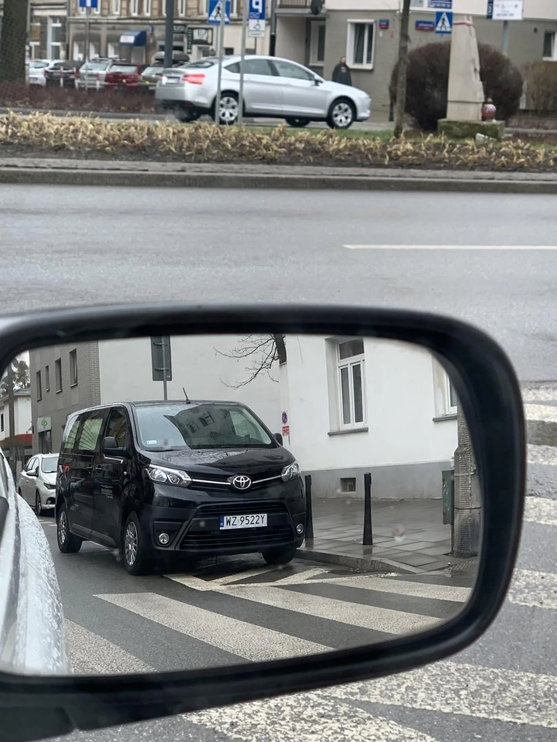 Pracownik zakładu pogrzebowego zajada się kanapeczką oczekując na potencjalnego klienta przez swój postój