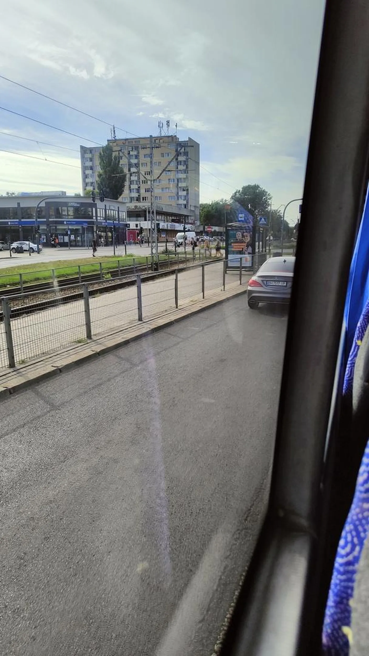 Kierowca z telefonem w ręku prowadzi samochód. Zachwouje się nadpobudliwie i gwałtownie hamuje.